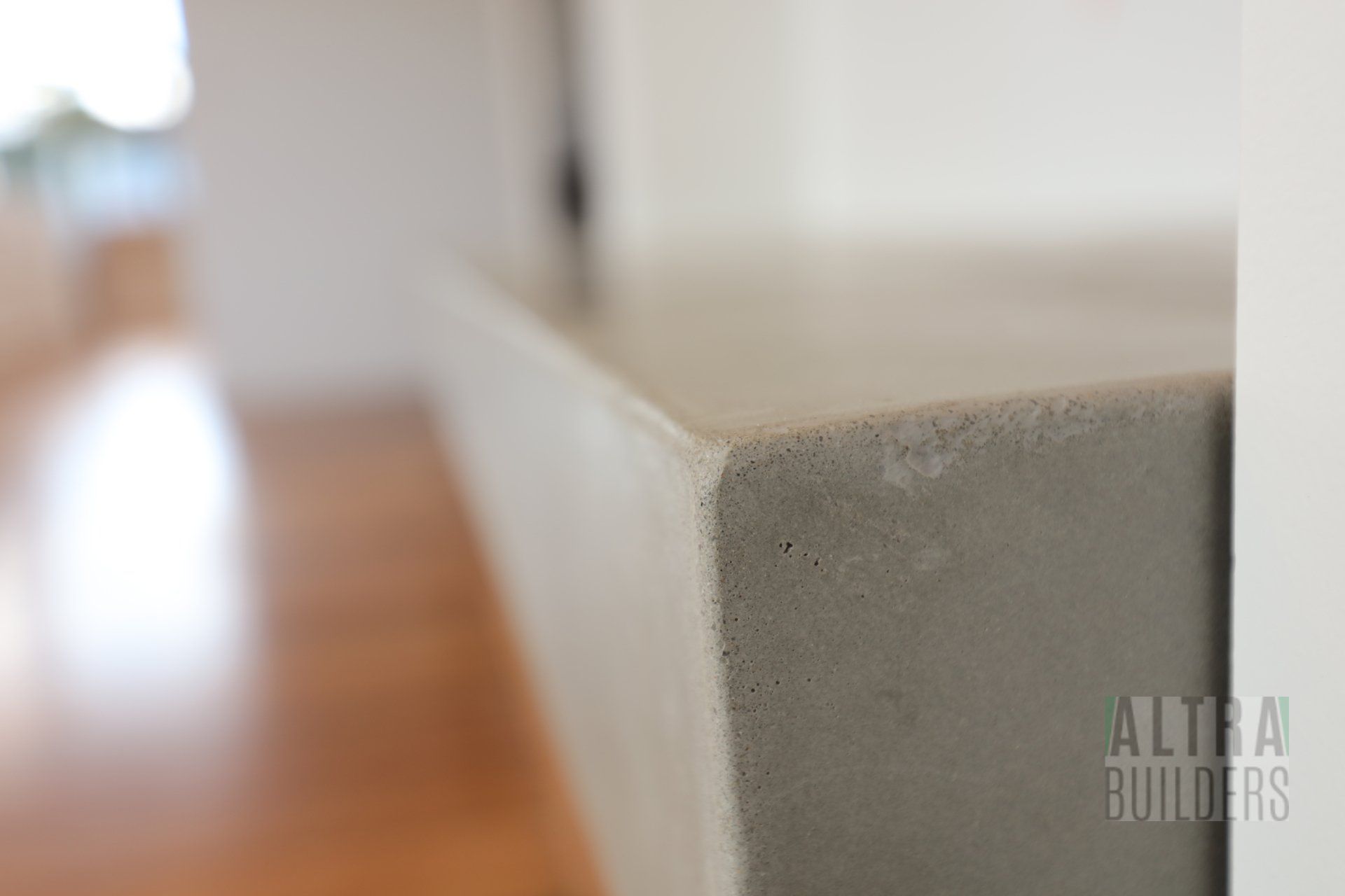 A close up of a concrete counter top in a living room.