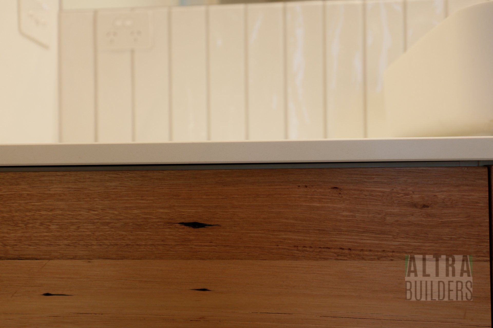 A bathroom vanity with a wooden drawer and a white counter top.