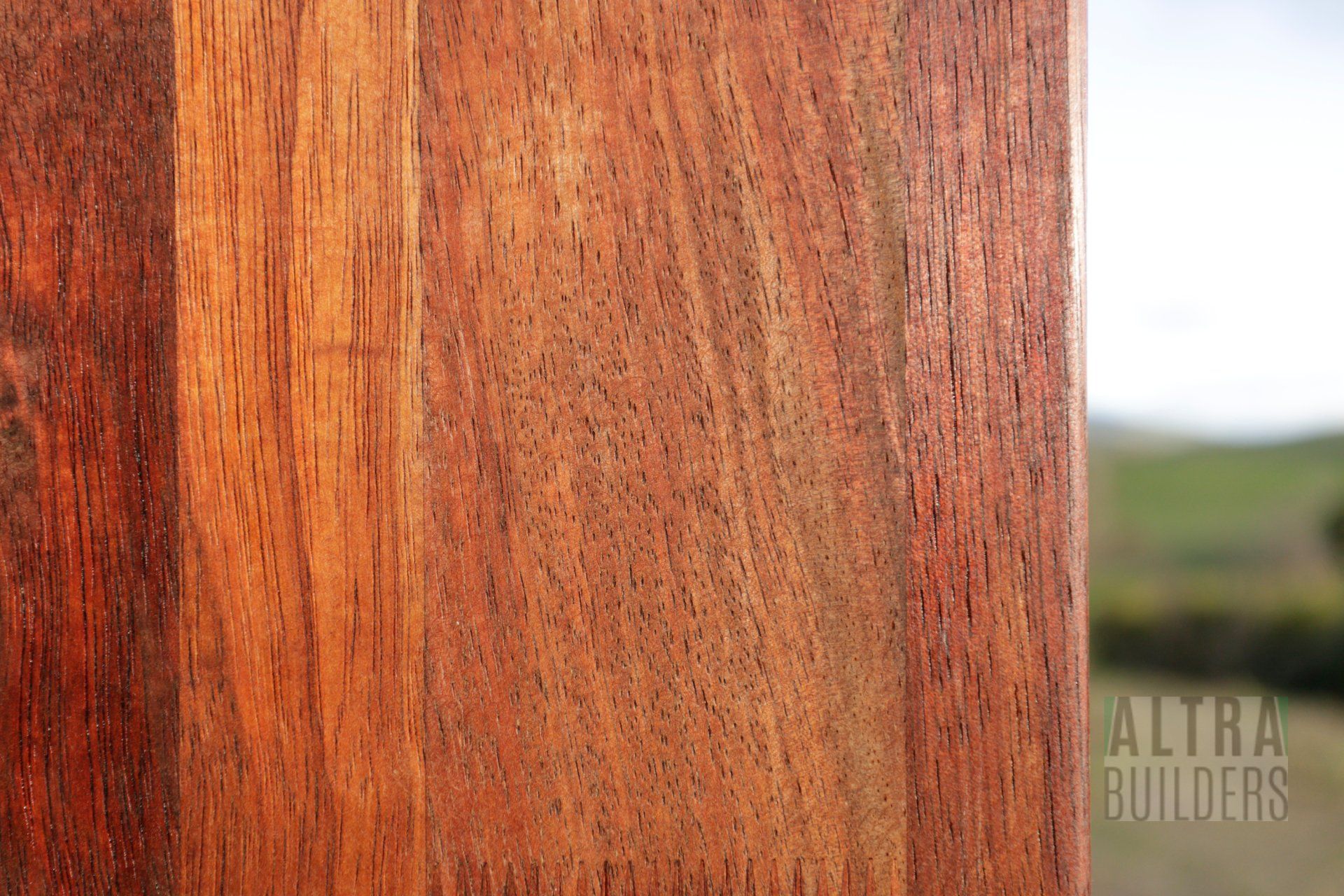 A close up of a piece of wood with a field in the background.