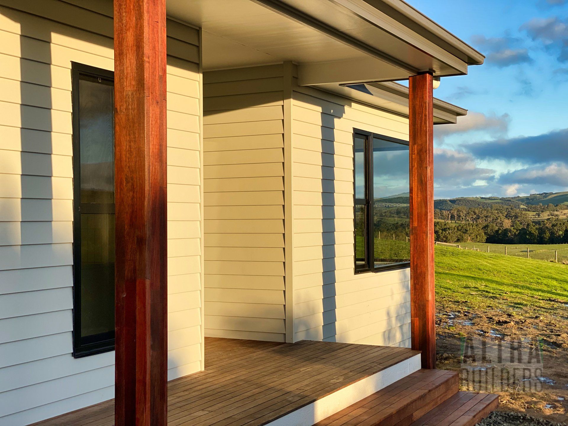 A white house with a wooden porch and stairs