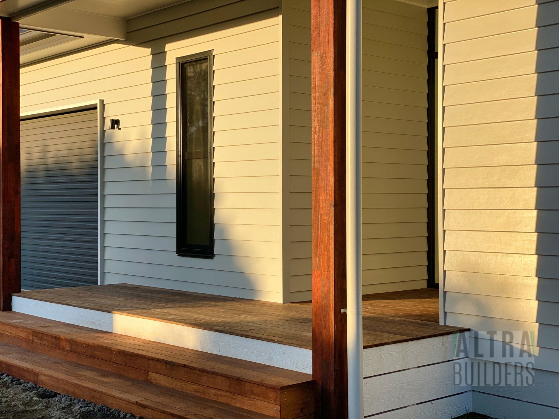 A white house with a wooden porch and stairs