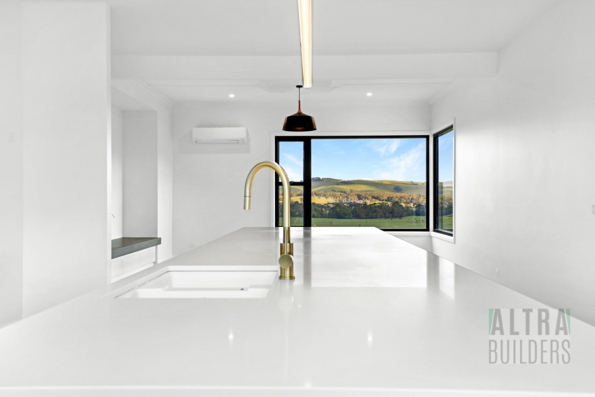 An empty kitchen with a sink and a window.
