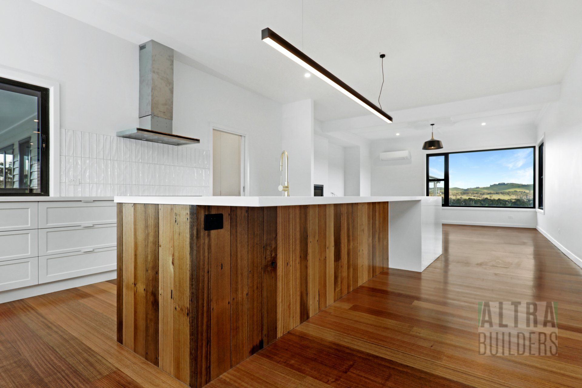 A kitchen with a wooden island and white cabinets