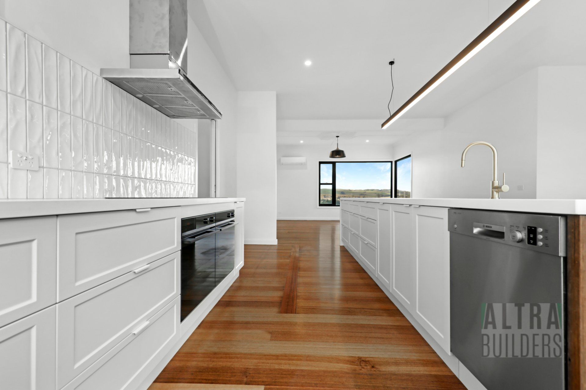 A kitchen with white cabinets and a black dishwasher