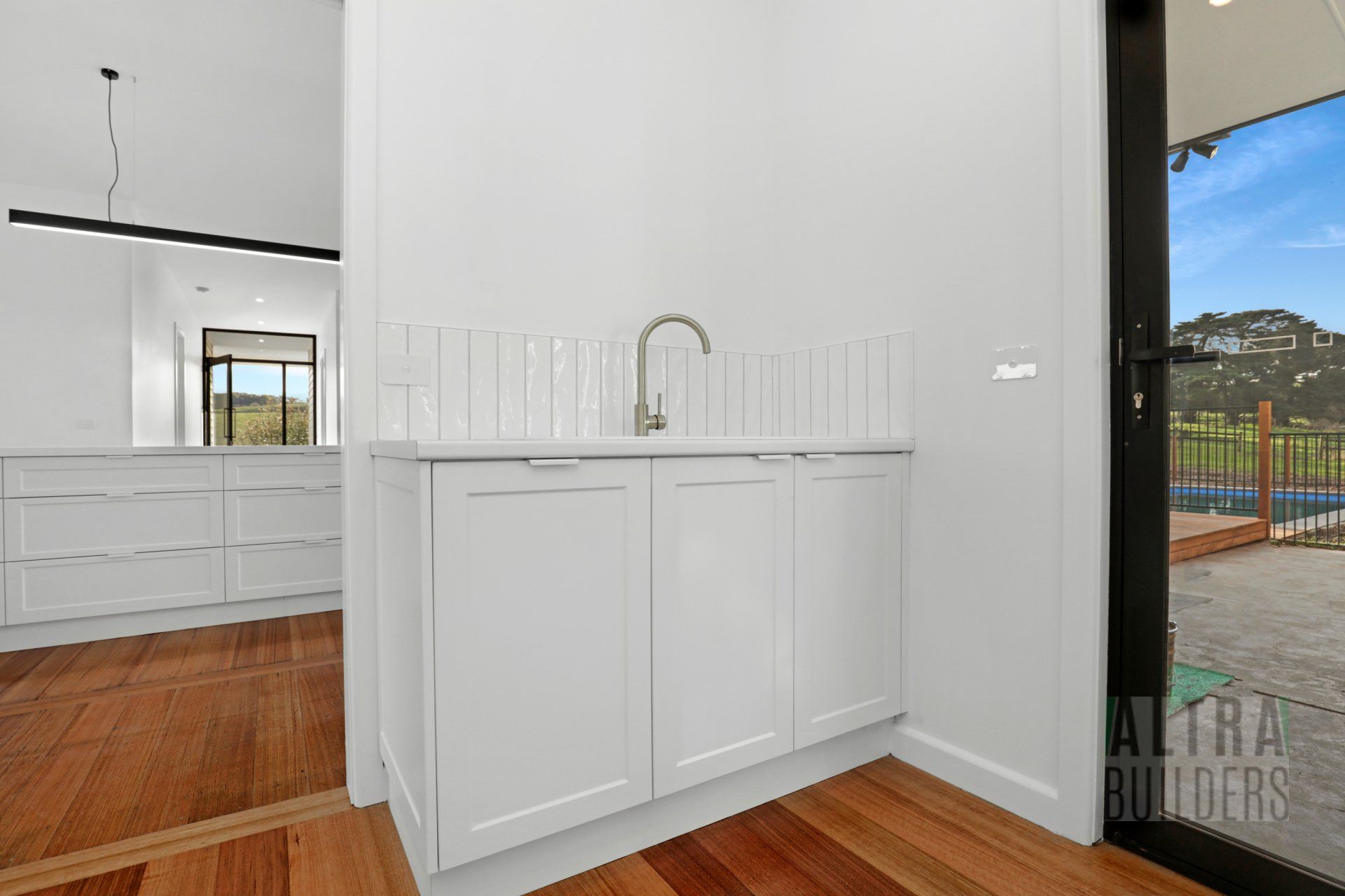 A kitchen with white cabinets and a sink.