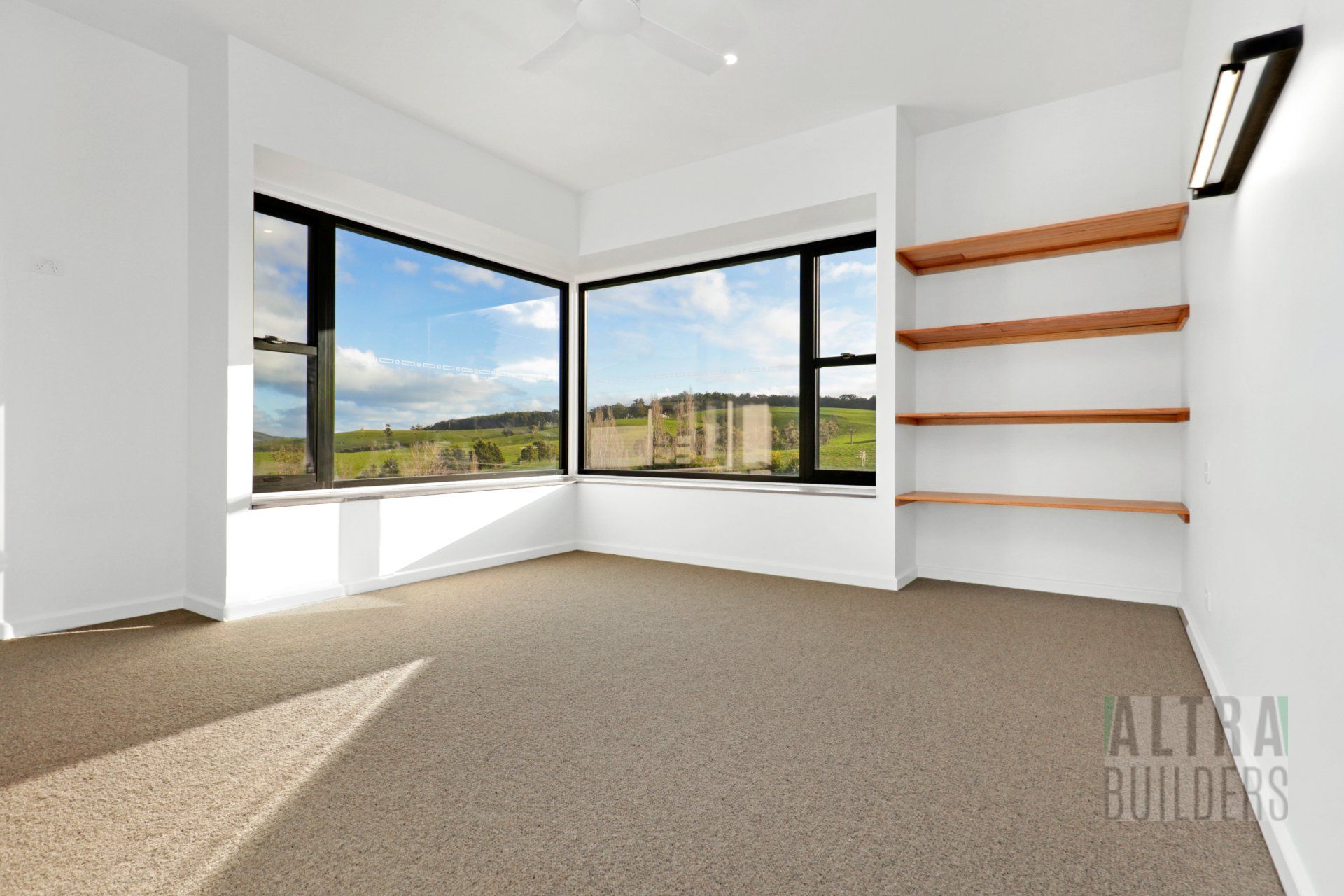 An empty room with shelves and a large window