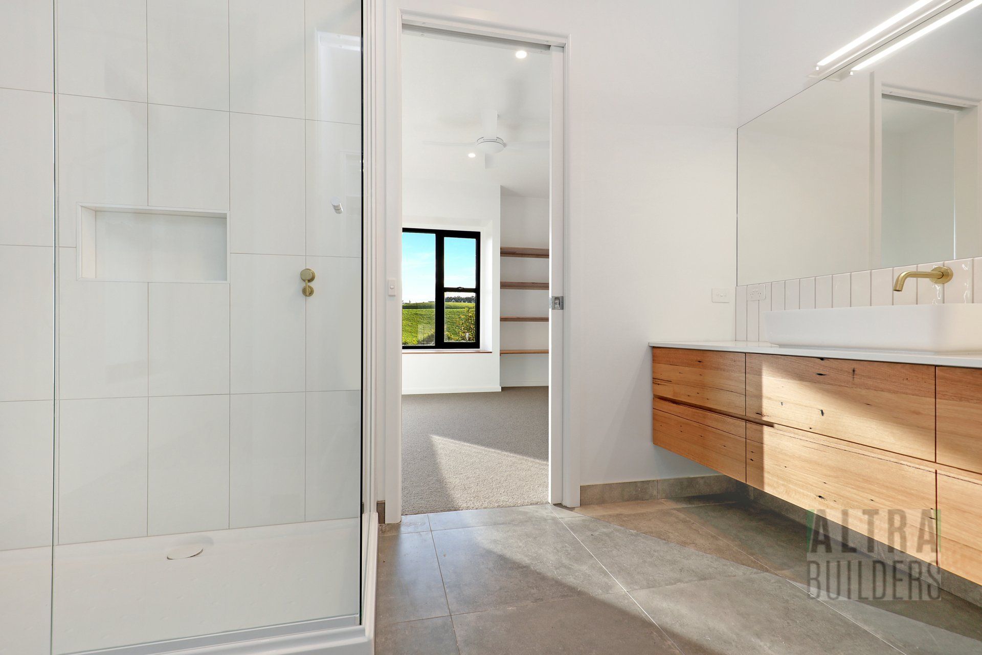 A bathroom with a walk in shower , sink and mirror.