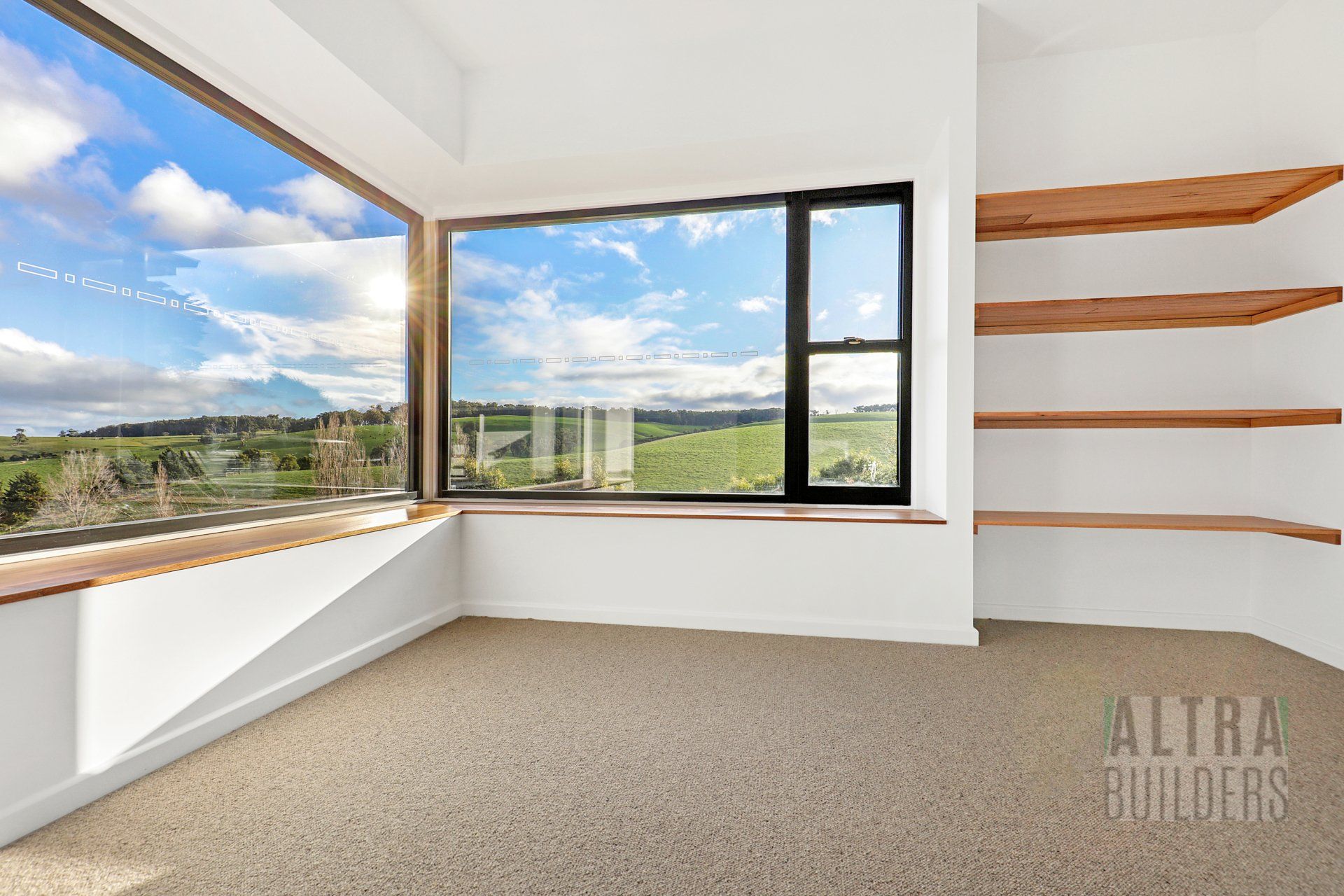 An empty room with a large window and wooden shelves