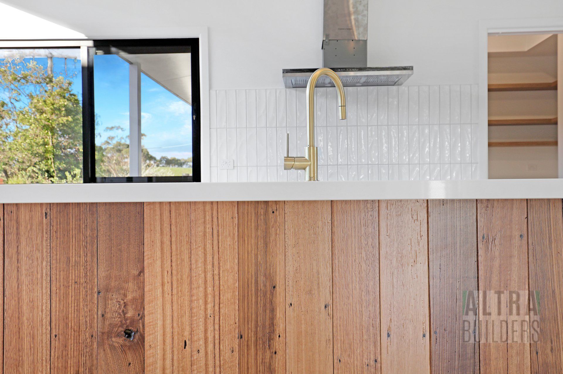A kitchen with wooden cabinets , a sink , and a window.