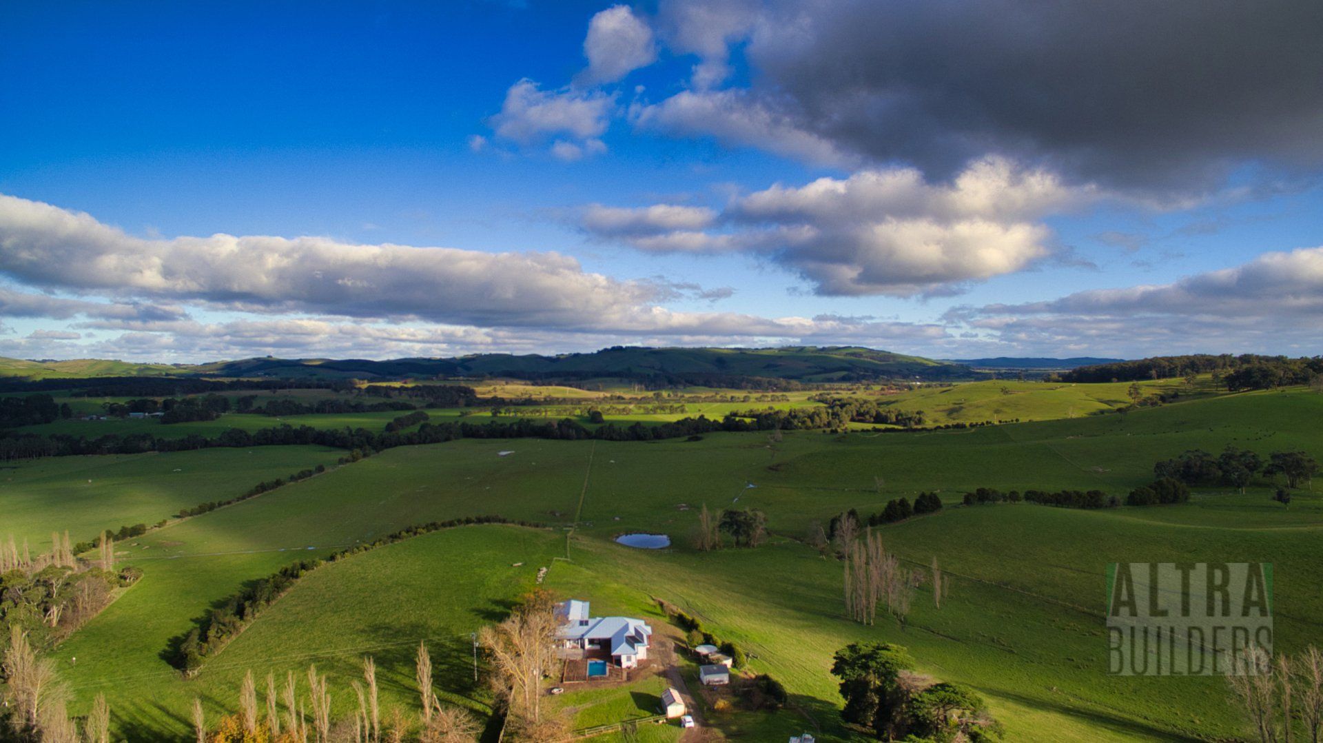 An aerial view of a farm in the middle of a lush green field.