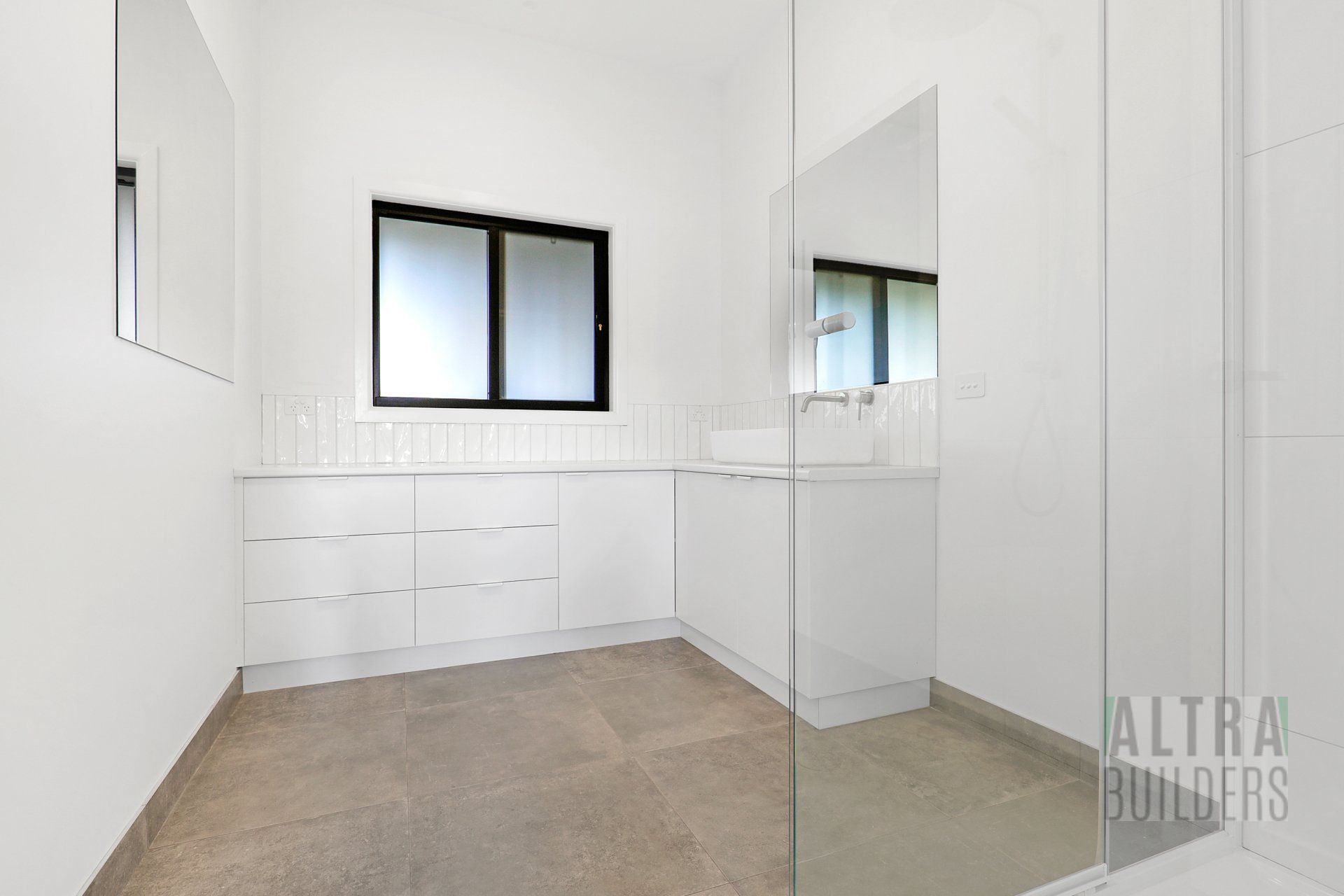 A bathroom with a sink , mirror and walk in shower.