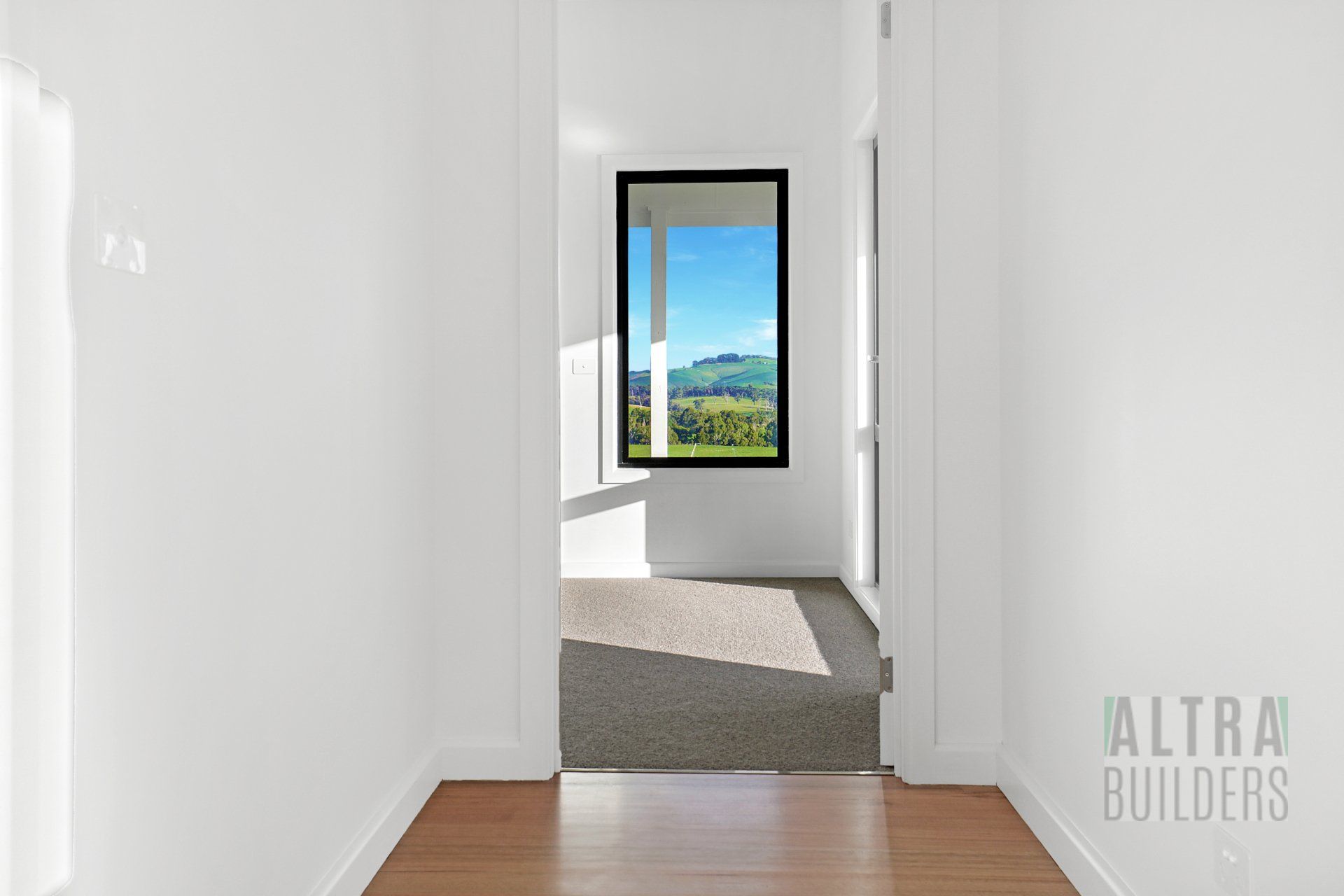 An empty hallway with a window in the middle of it.