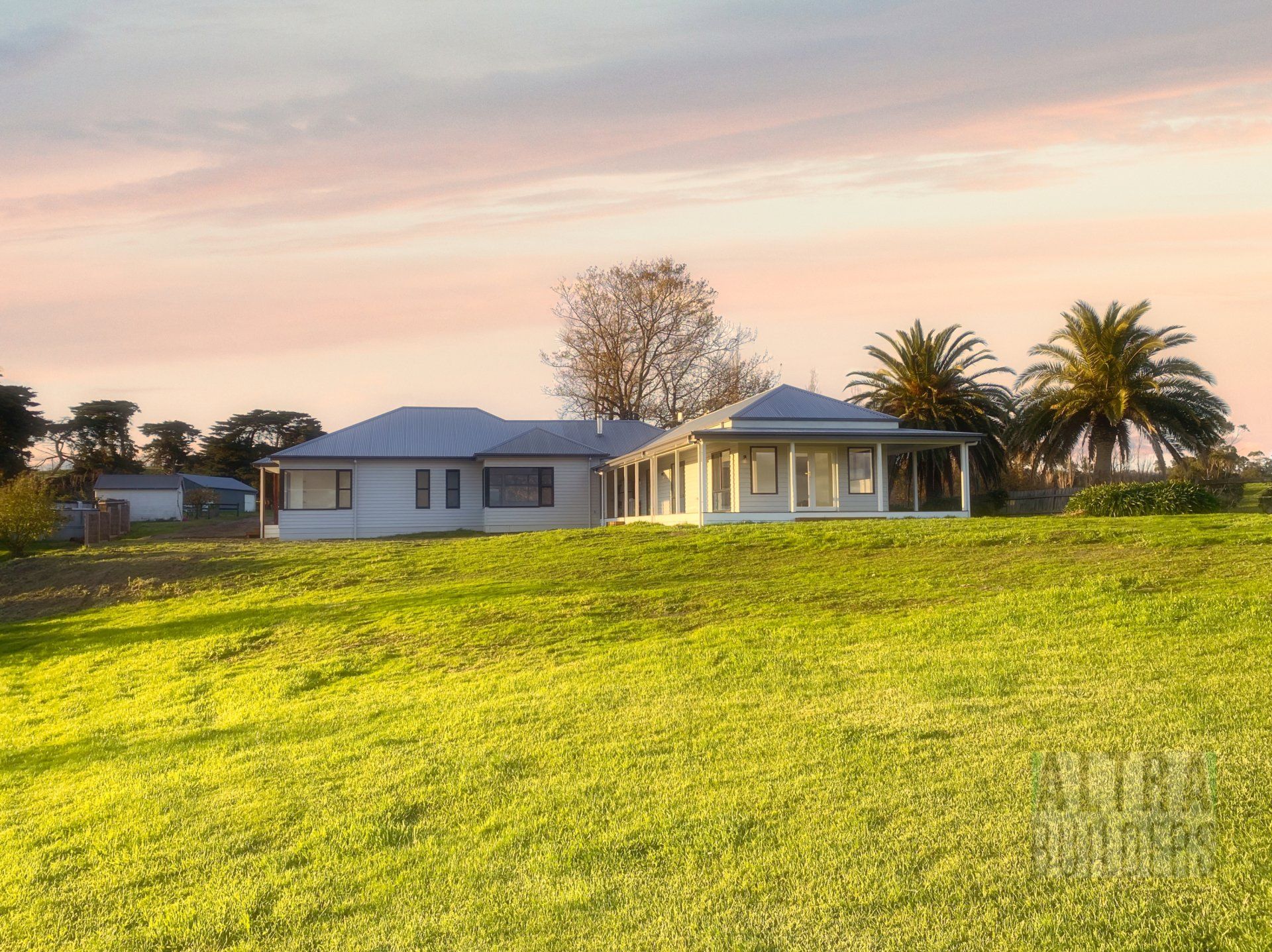 A house is sitting in the middle of a grassy field.