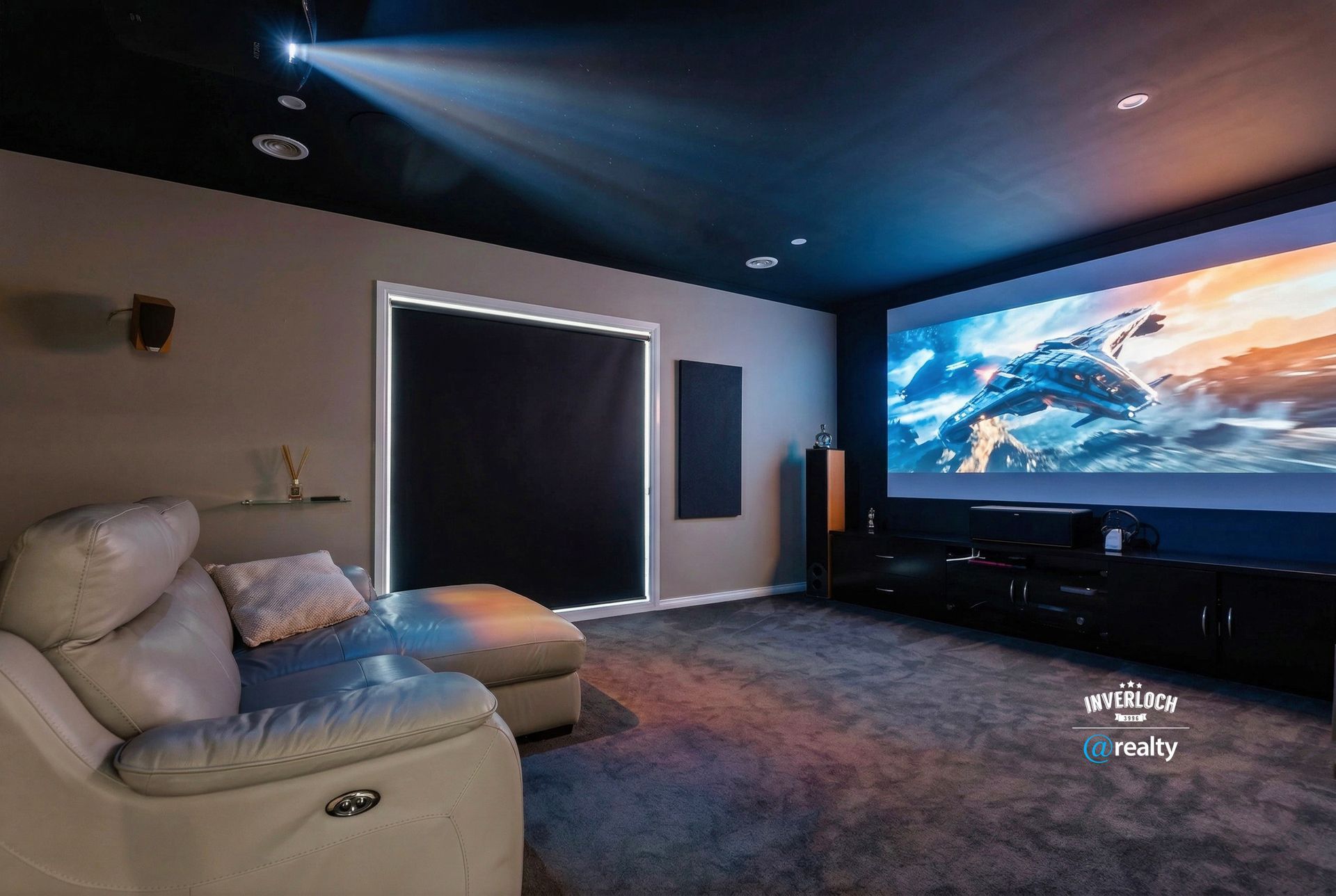 A home theater with a projection screen, dark ceiling, grey carpet, and a light-colored sofa.