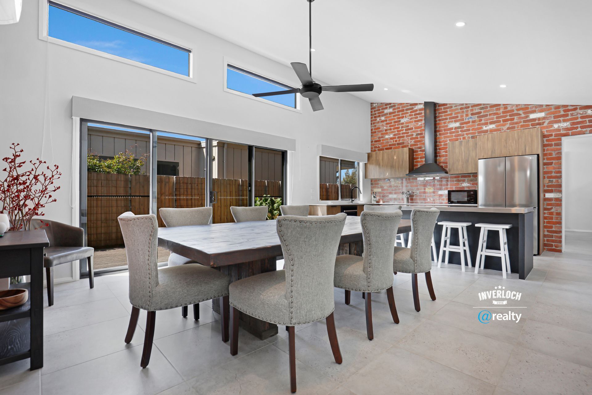 A dining room with a table and chairs and a ceiling fan.