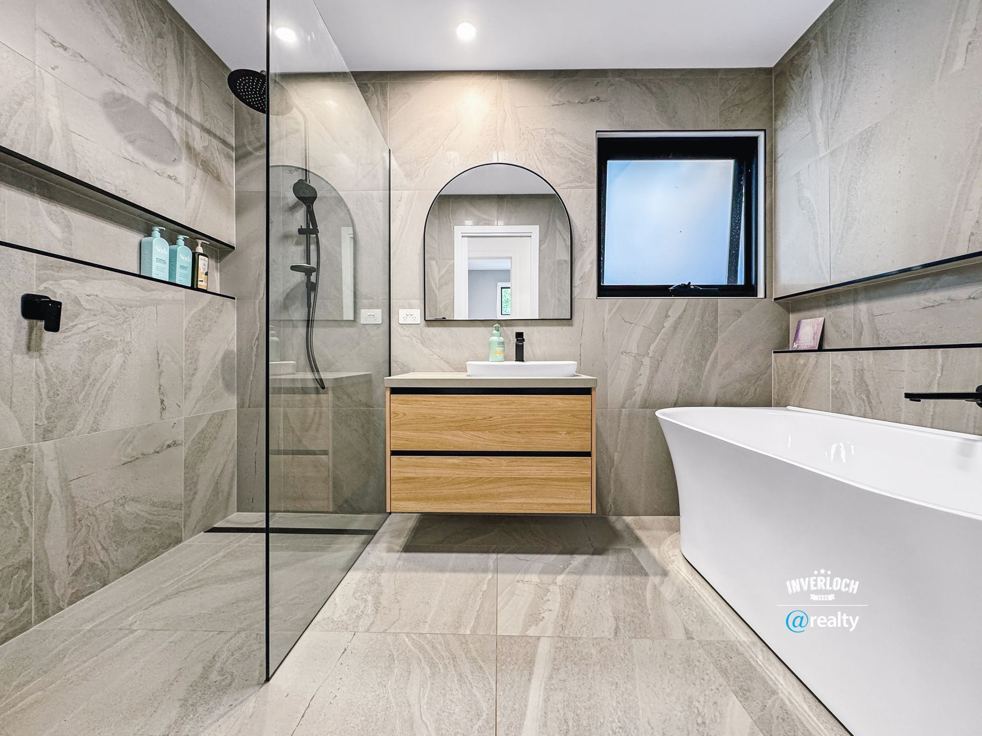 A bathroom with a bathtub , sink , shower and mirror.