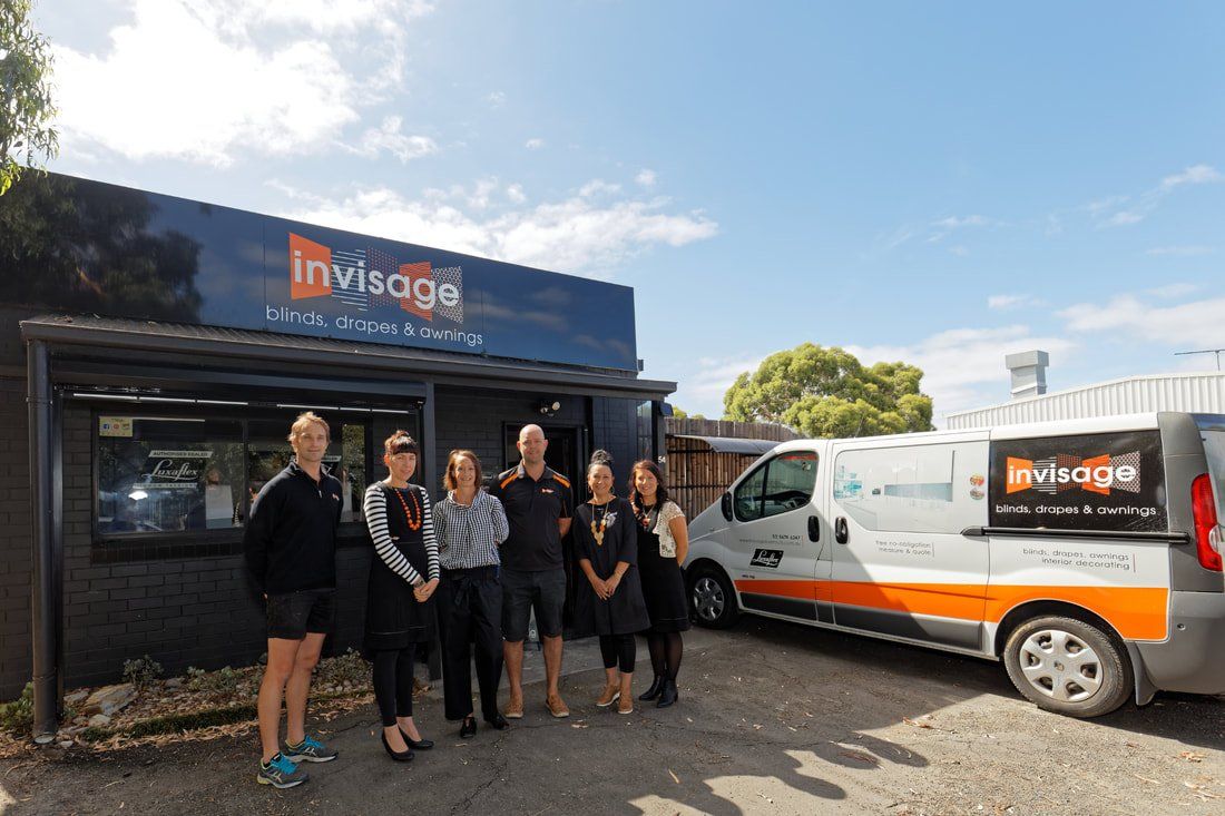 A group of people standing in front of a building and a van.