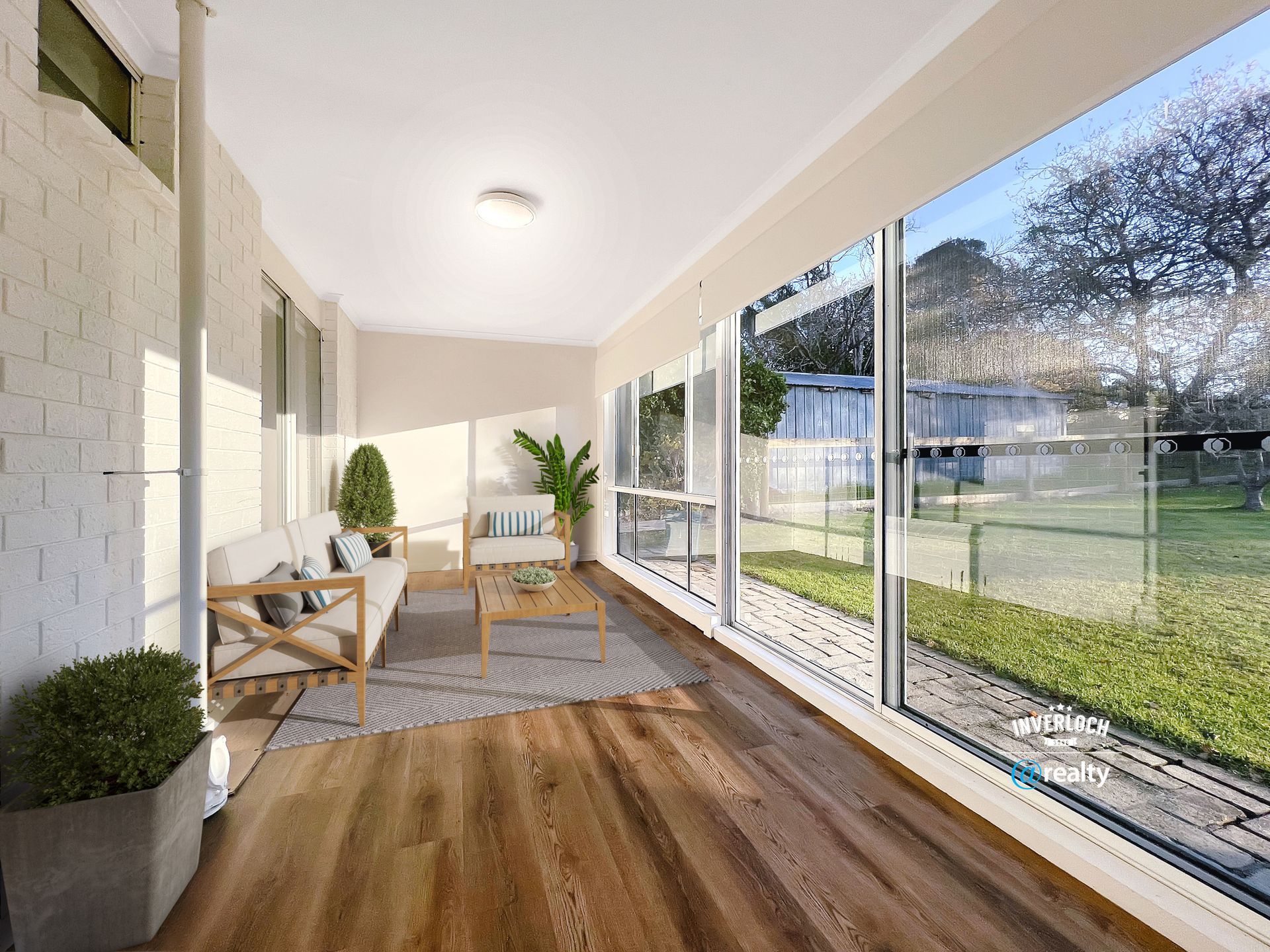 A living room with hardwood floors , a couch , chairs and a table.