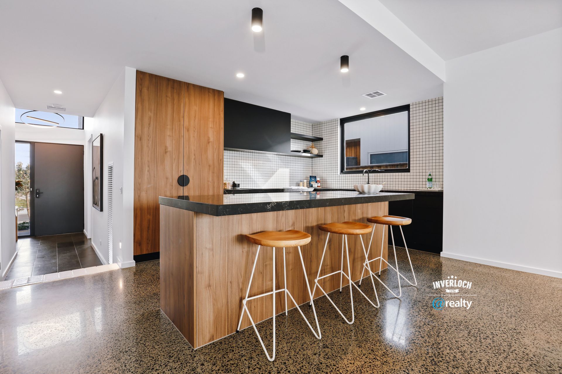 A kitchen with a large island and stools.