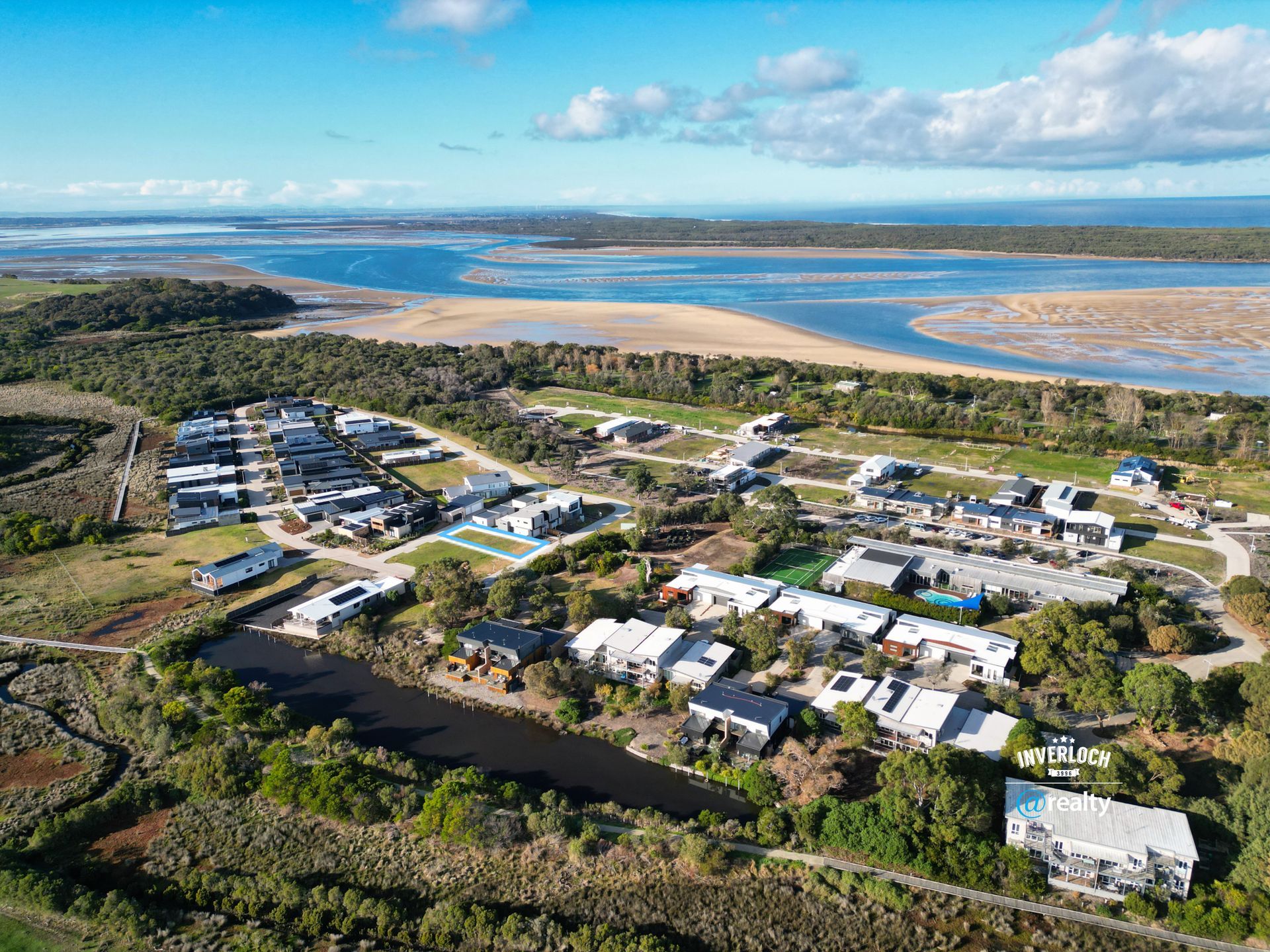 An aerial view of a residential area next to a body of water.