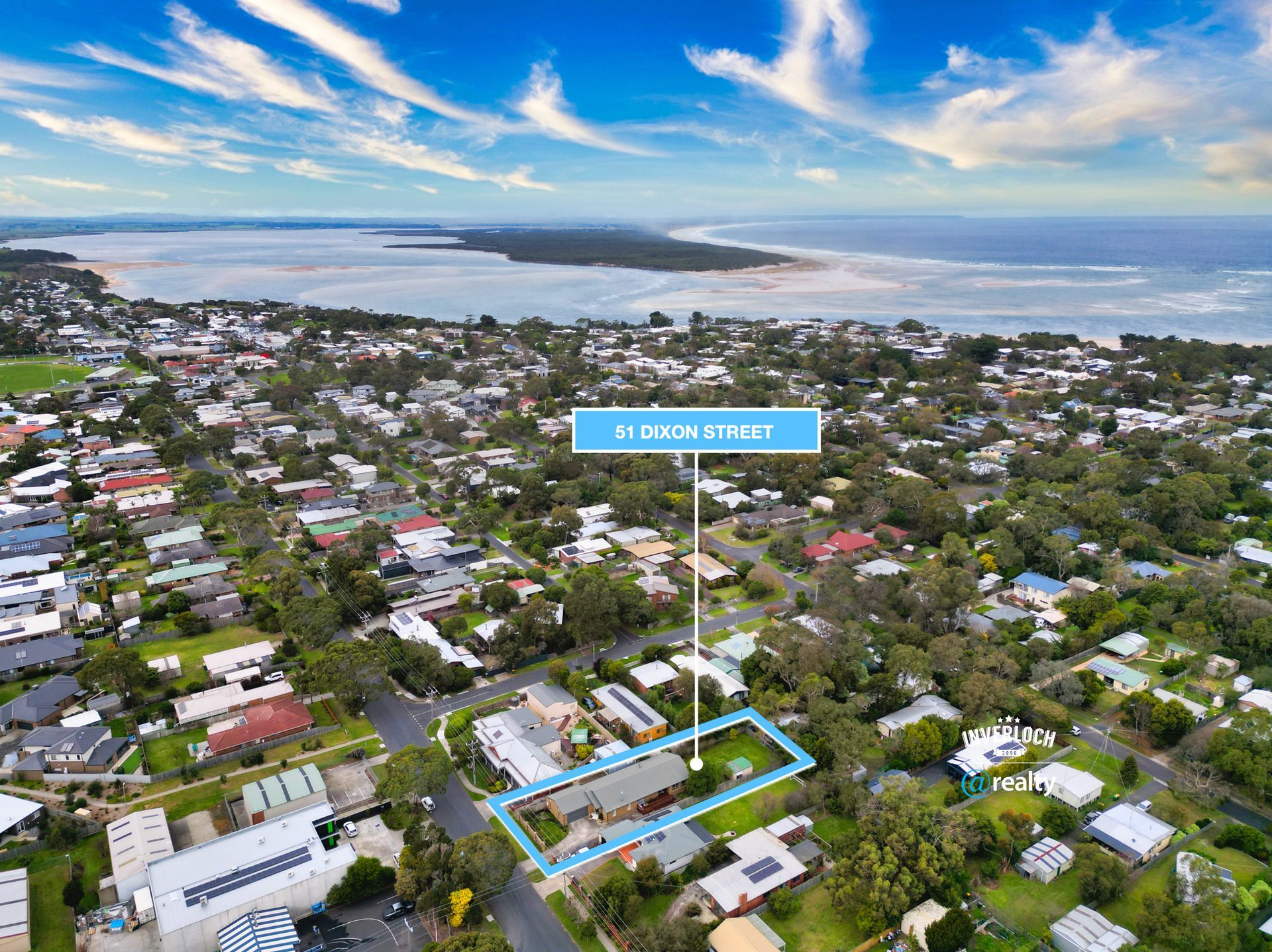 An aerial view of a residential area with a large body of water in the background.