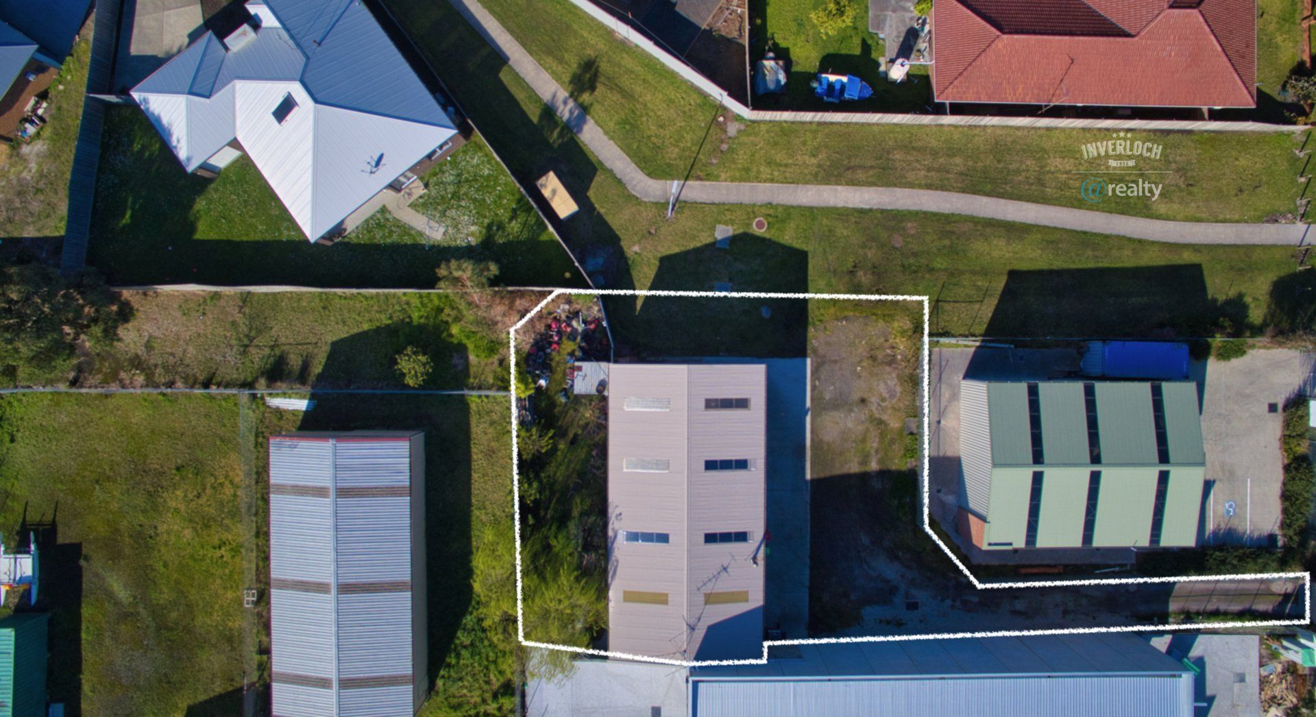 An aerial view of a residential area with houses and sheds.