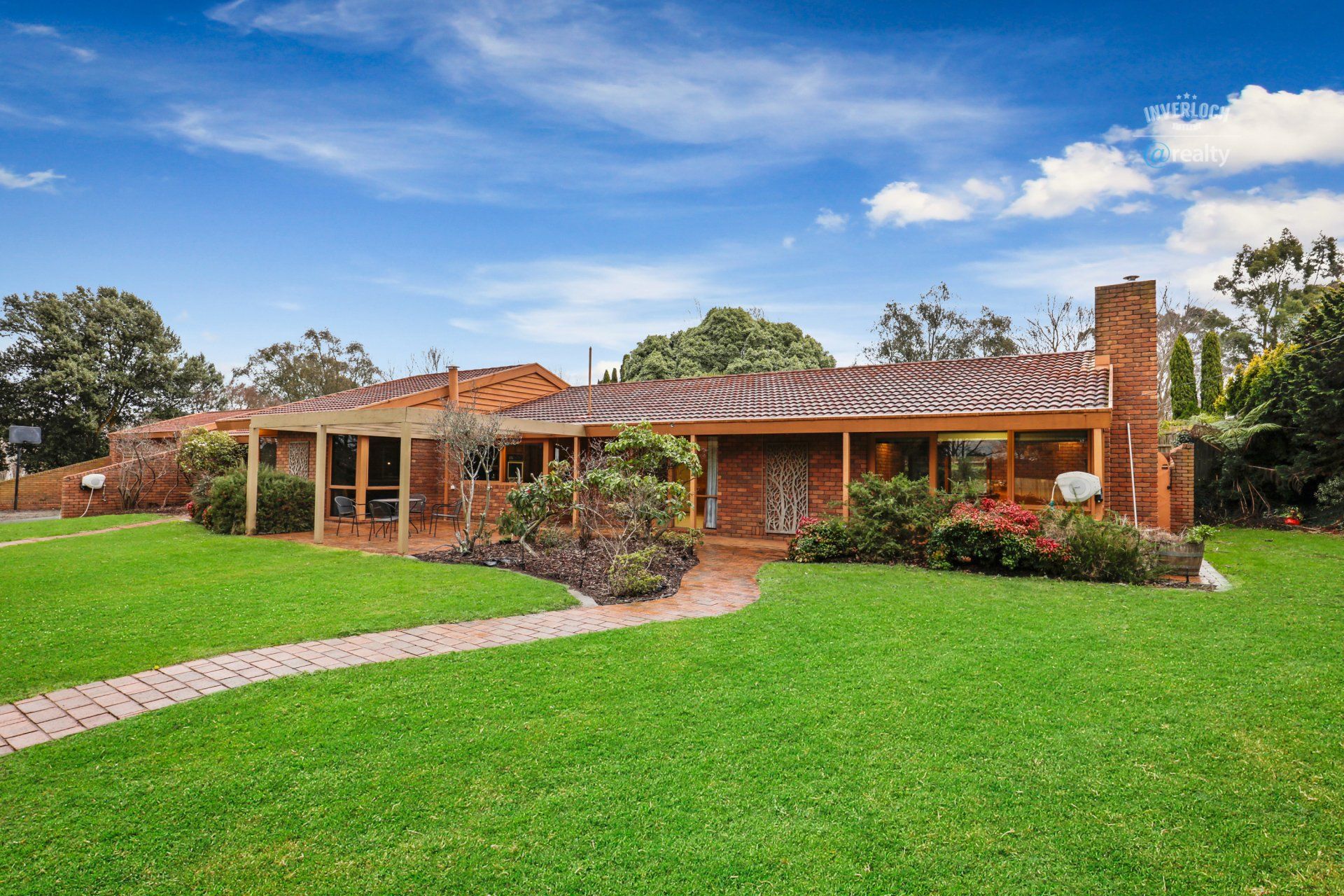 A large brick house with a lush green lawn in front of it.