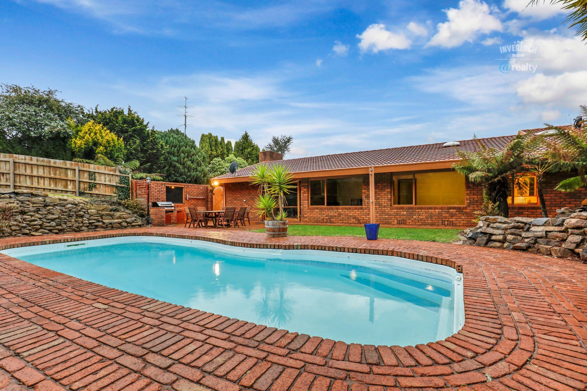 There is a large swimming pool in the backyard of a house.