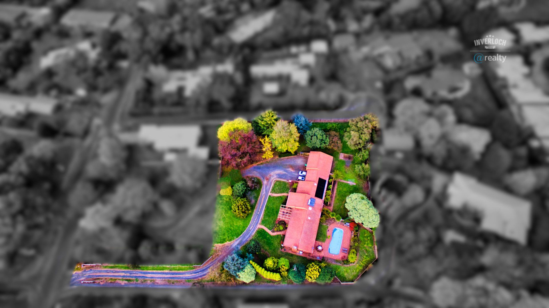 An aerial view of a house surrounded by trees and bushes.