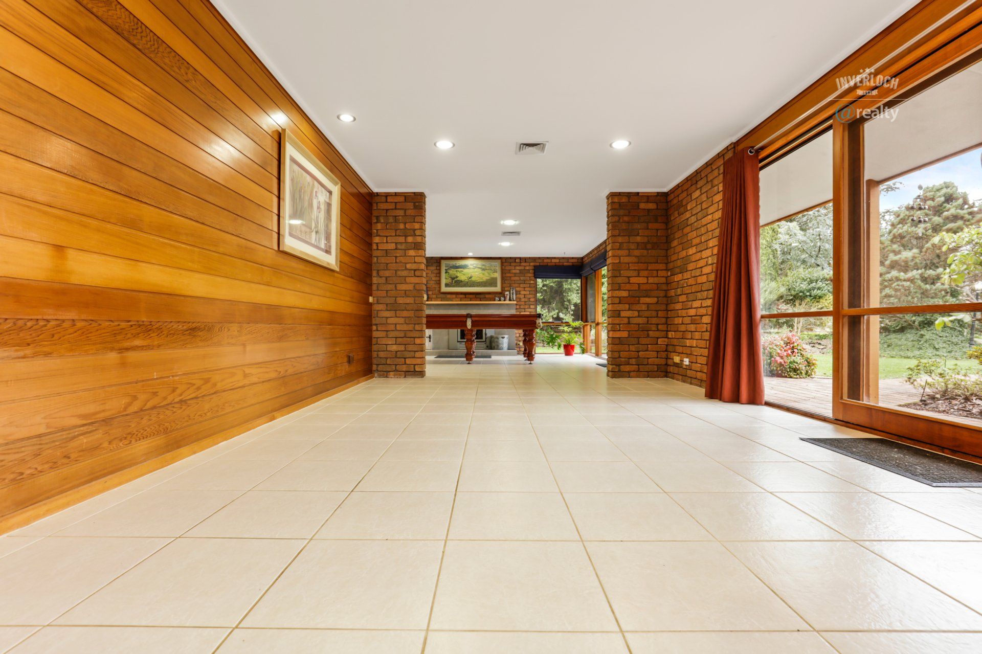 A large empty room with tile floors and wooden walls.