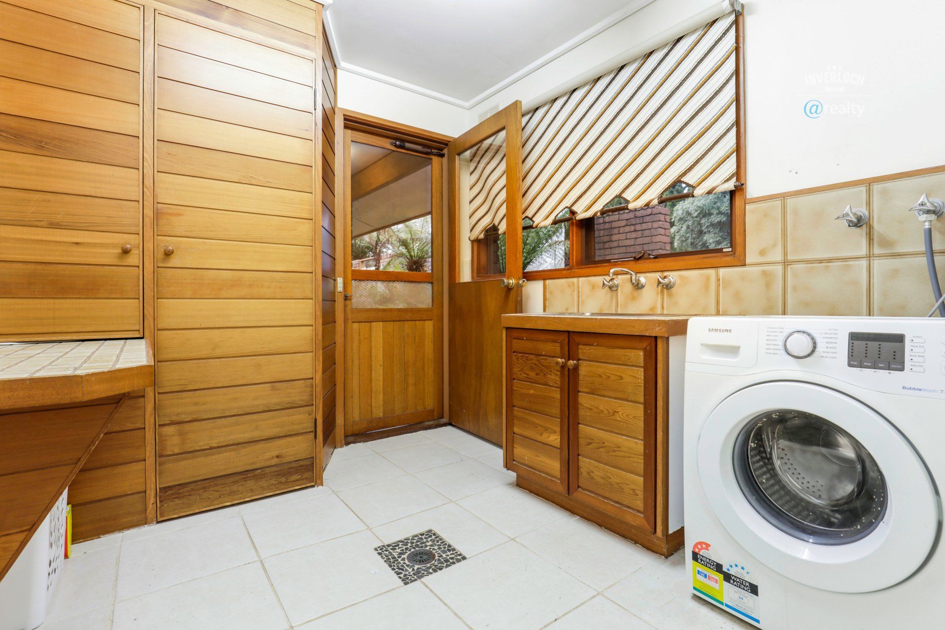 A laundry room with a washing machine and a sink.