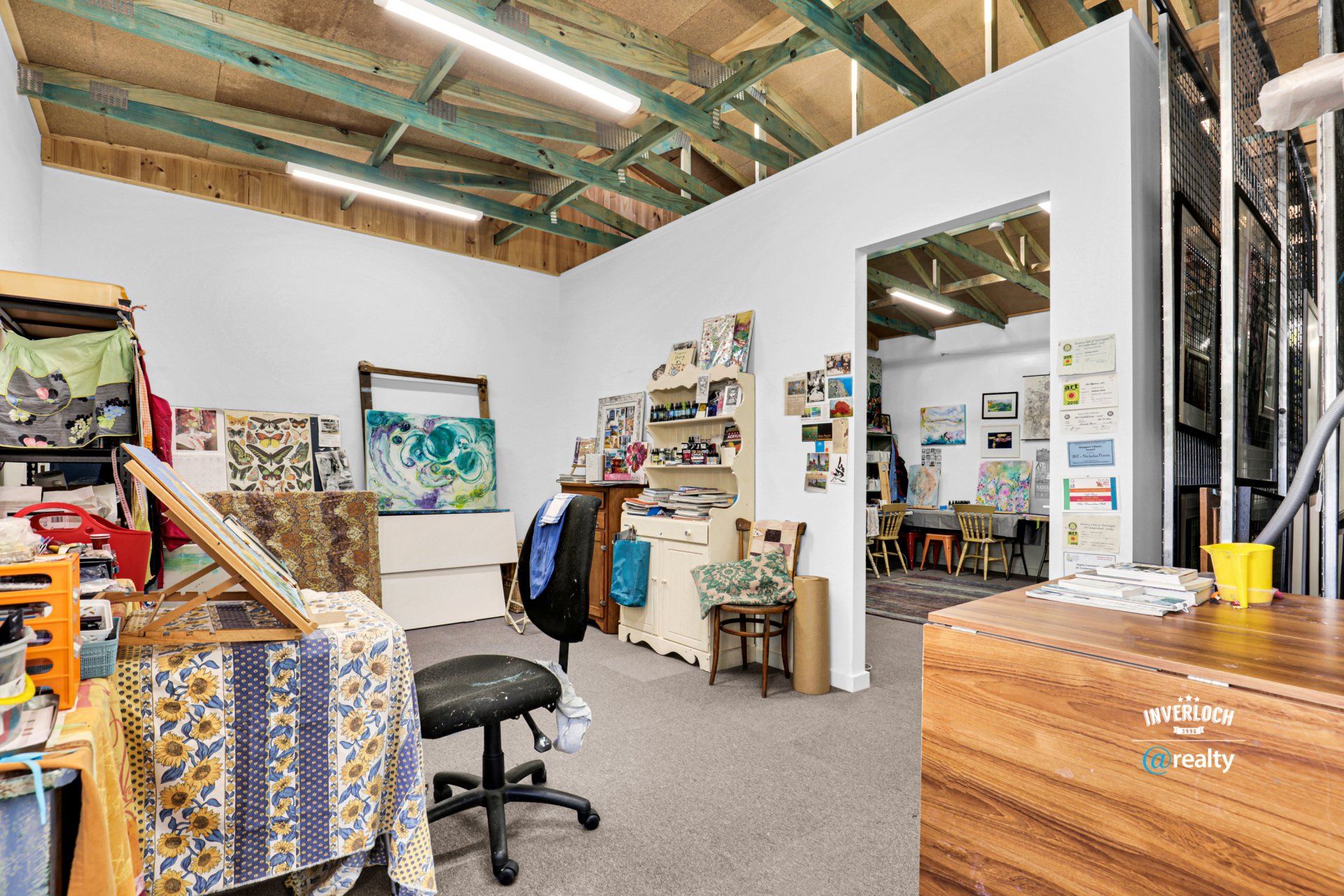 A room with a lot of furniture and paintings on the wall.