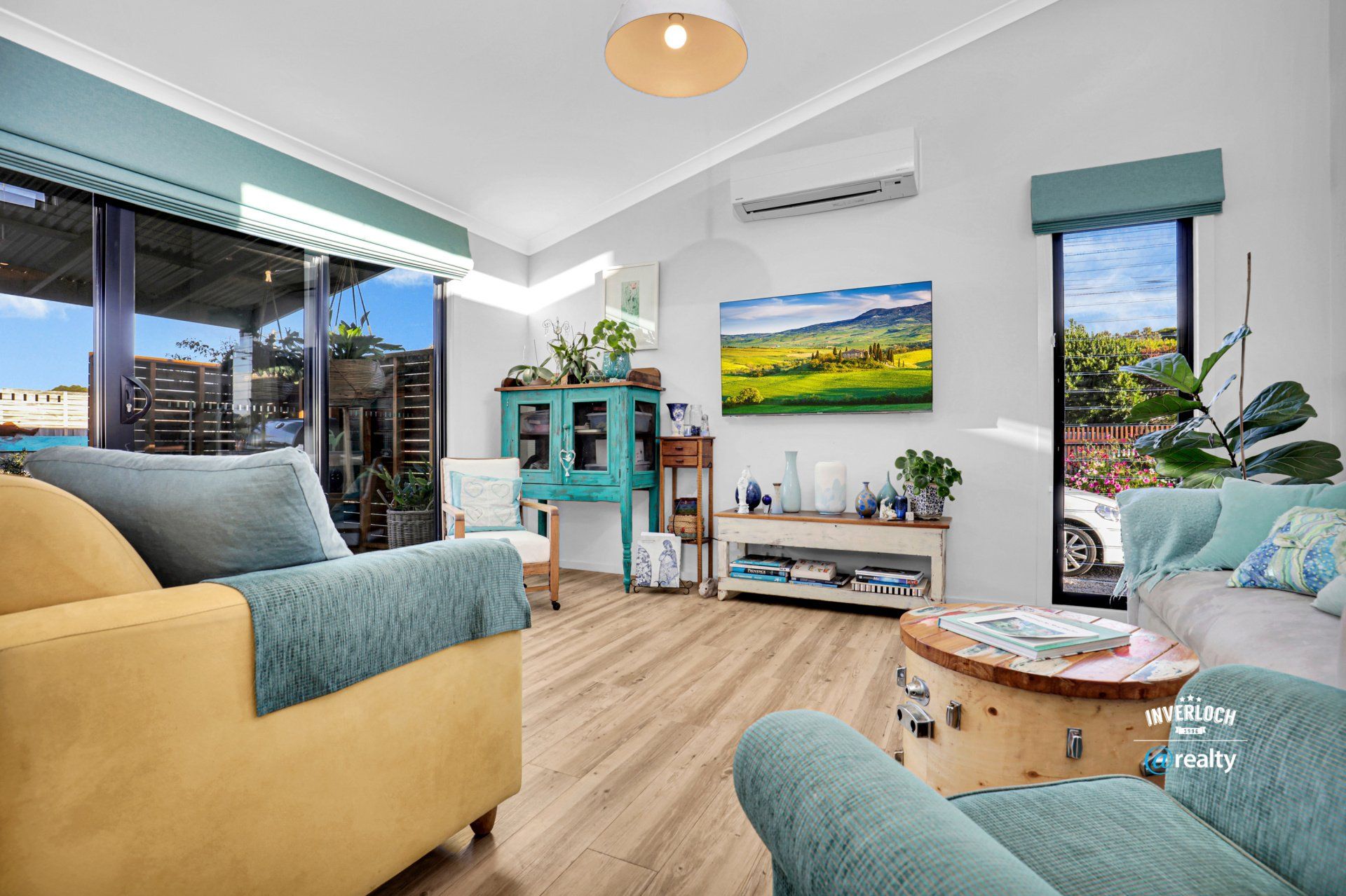 A living room with a couch , chair , table and television.