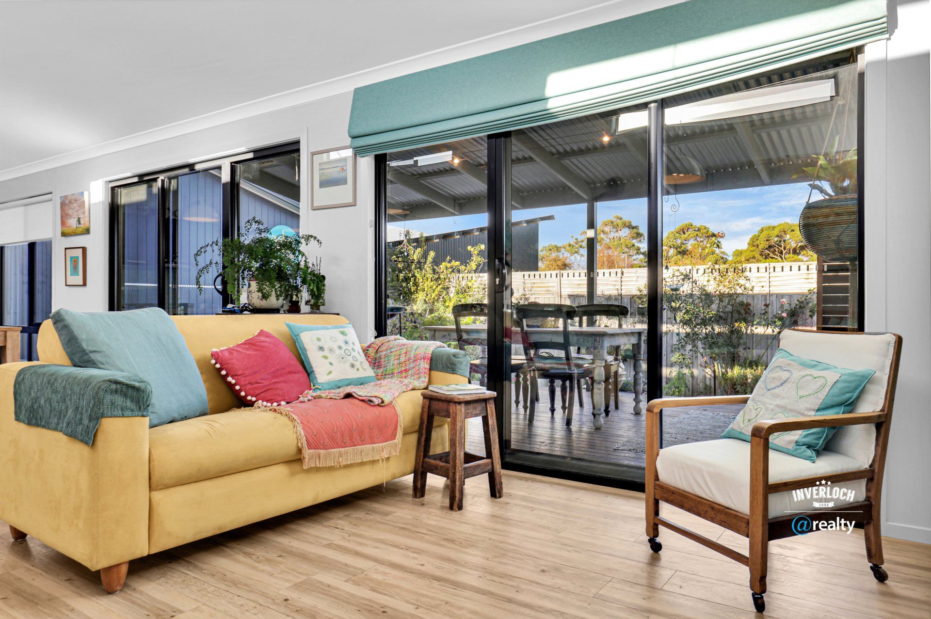 A living room with a yellow couch and two chairs.