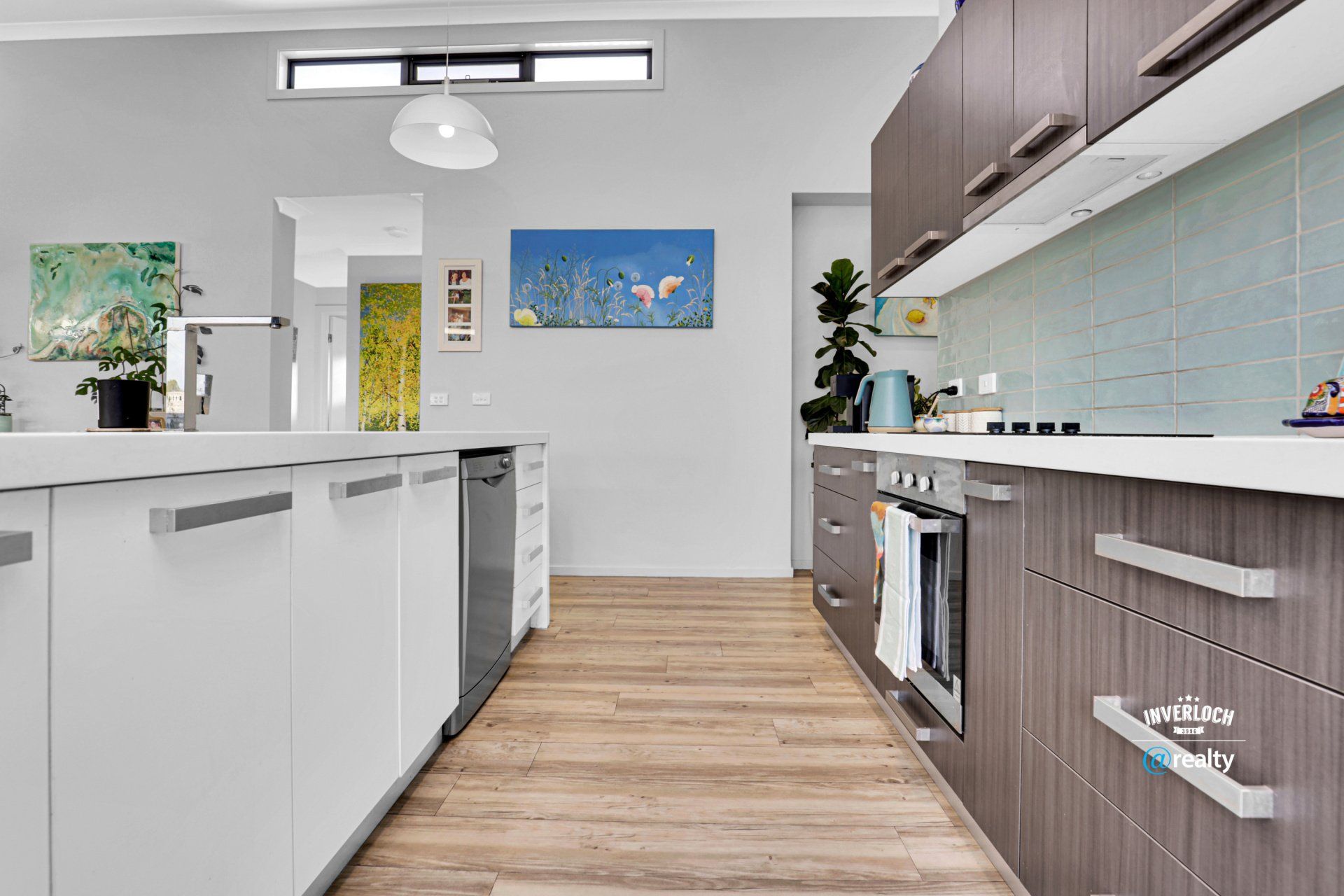 A kitchen with white cabinets and wooden floors