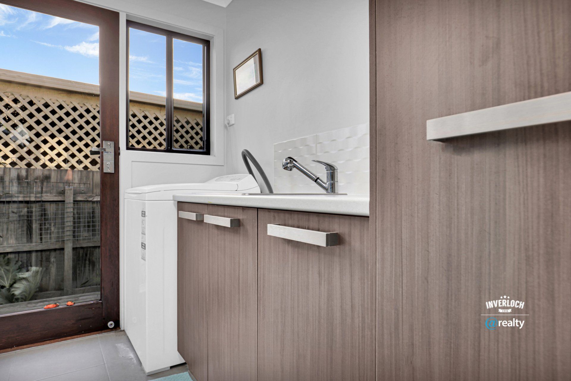 A kitchen with a sink , cabinets and a window.