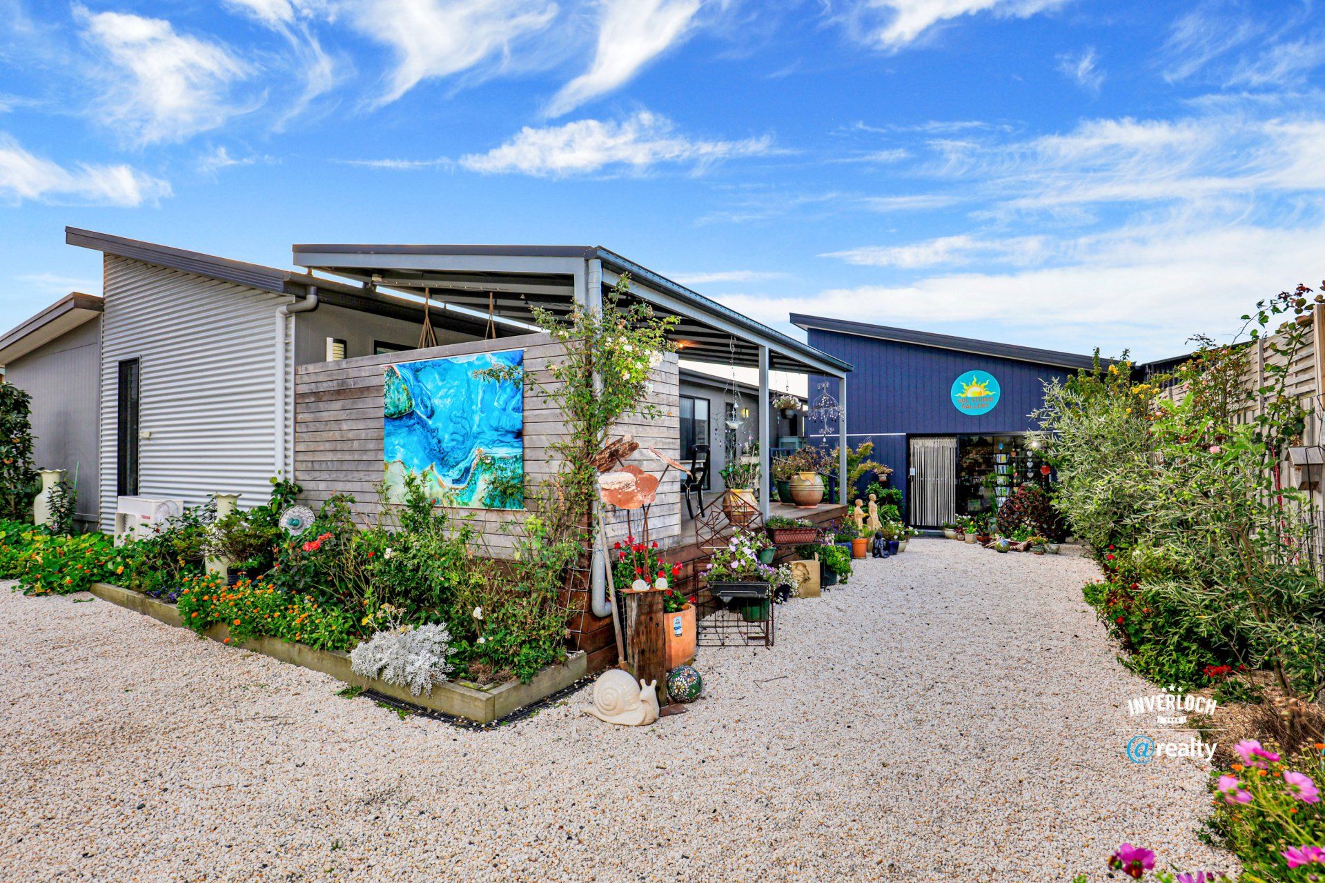 A large house with a lot of plants and flowers in front of it.