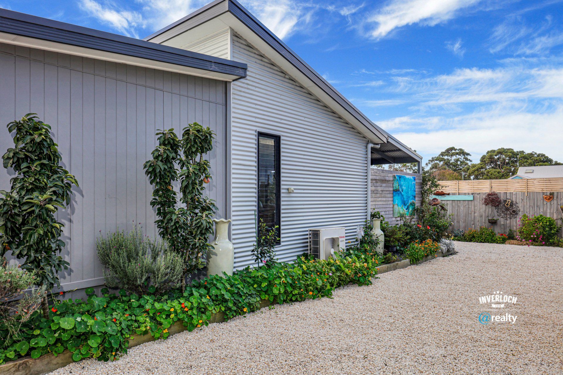 A house with a gravel driveway in front of it.