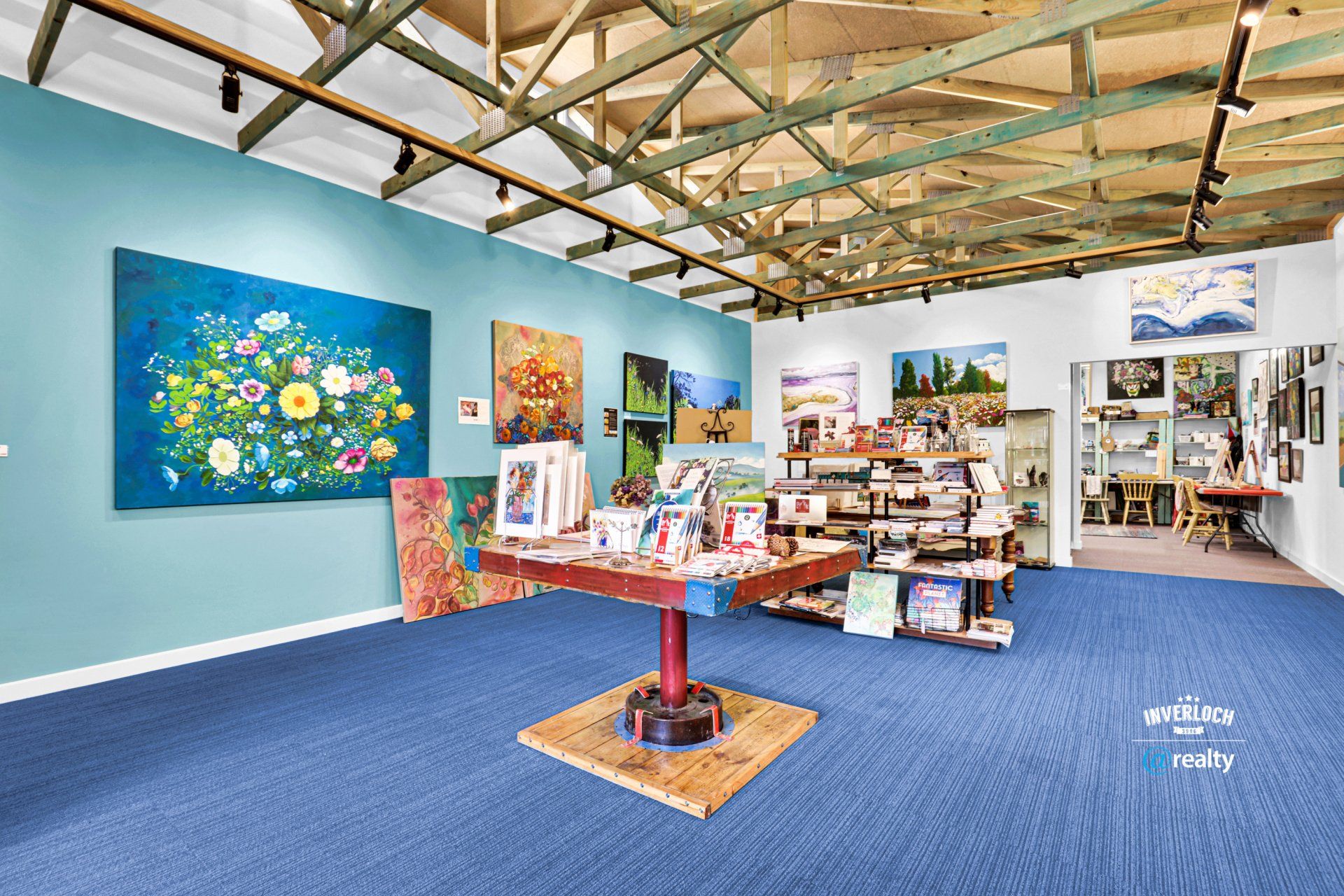 A room with a table and paintings on the walls.