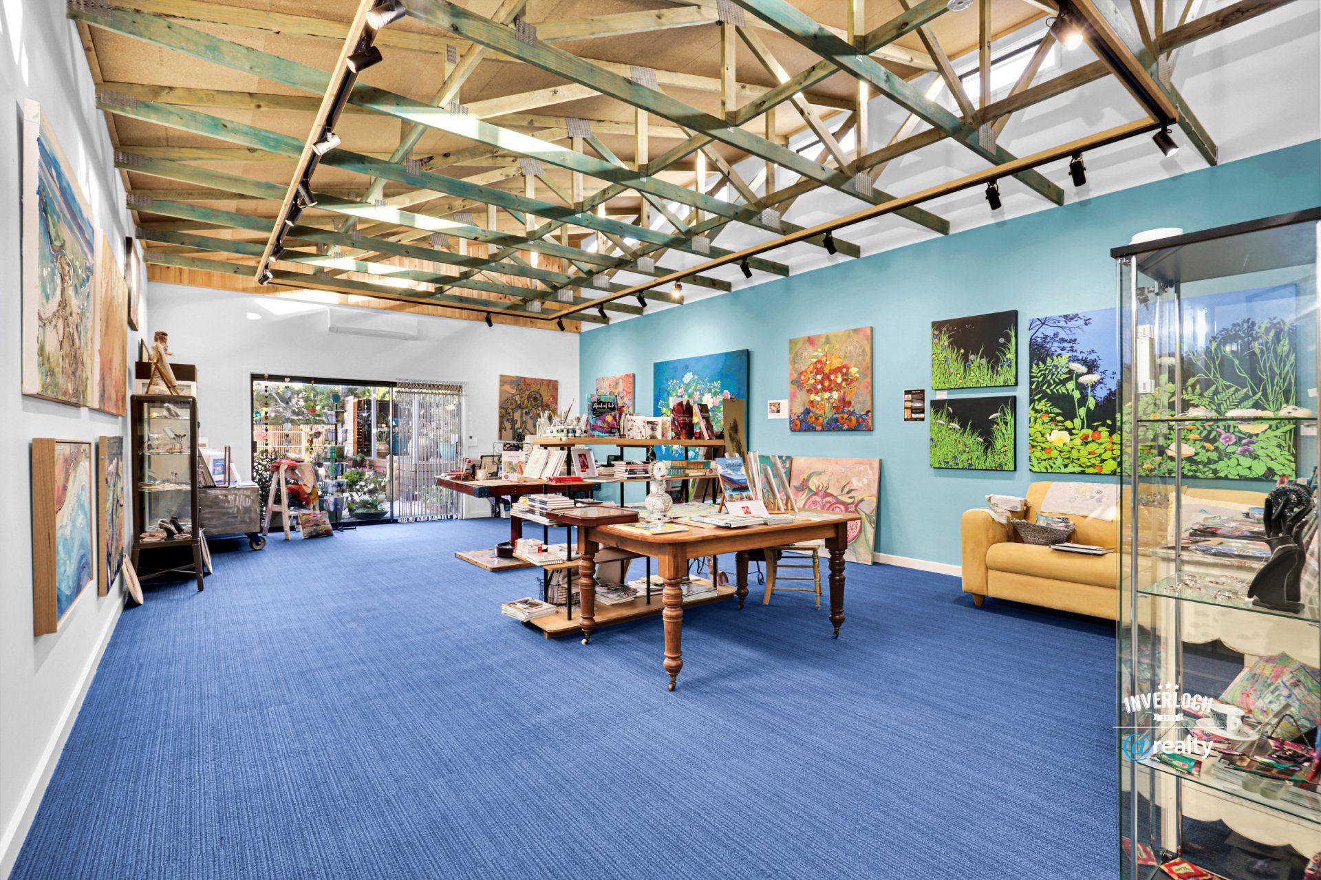 A large room filled with furniture and paintings on the walls.