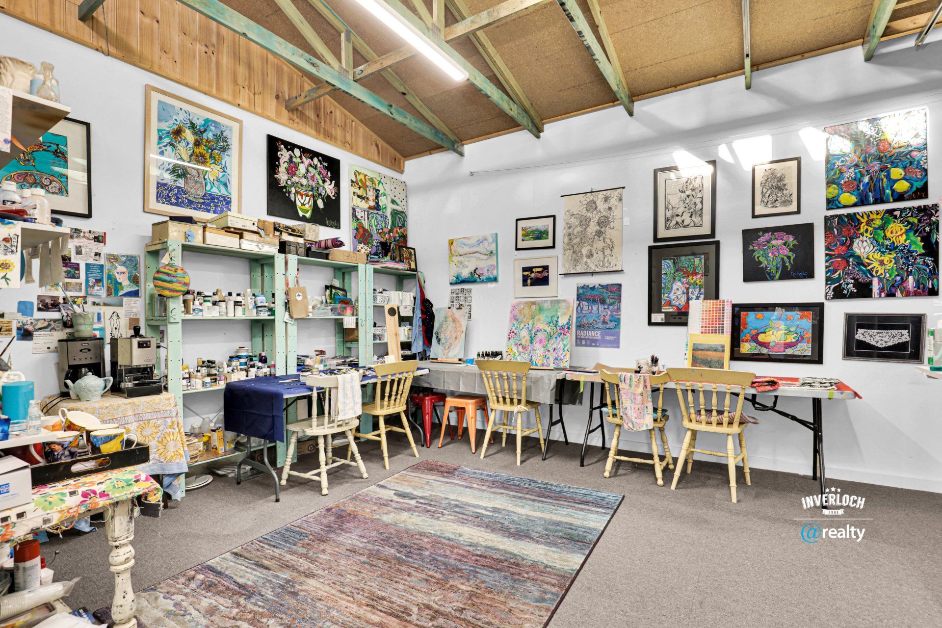 A room filled with tables and chairs and paintings on the wall.
