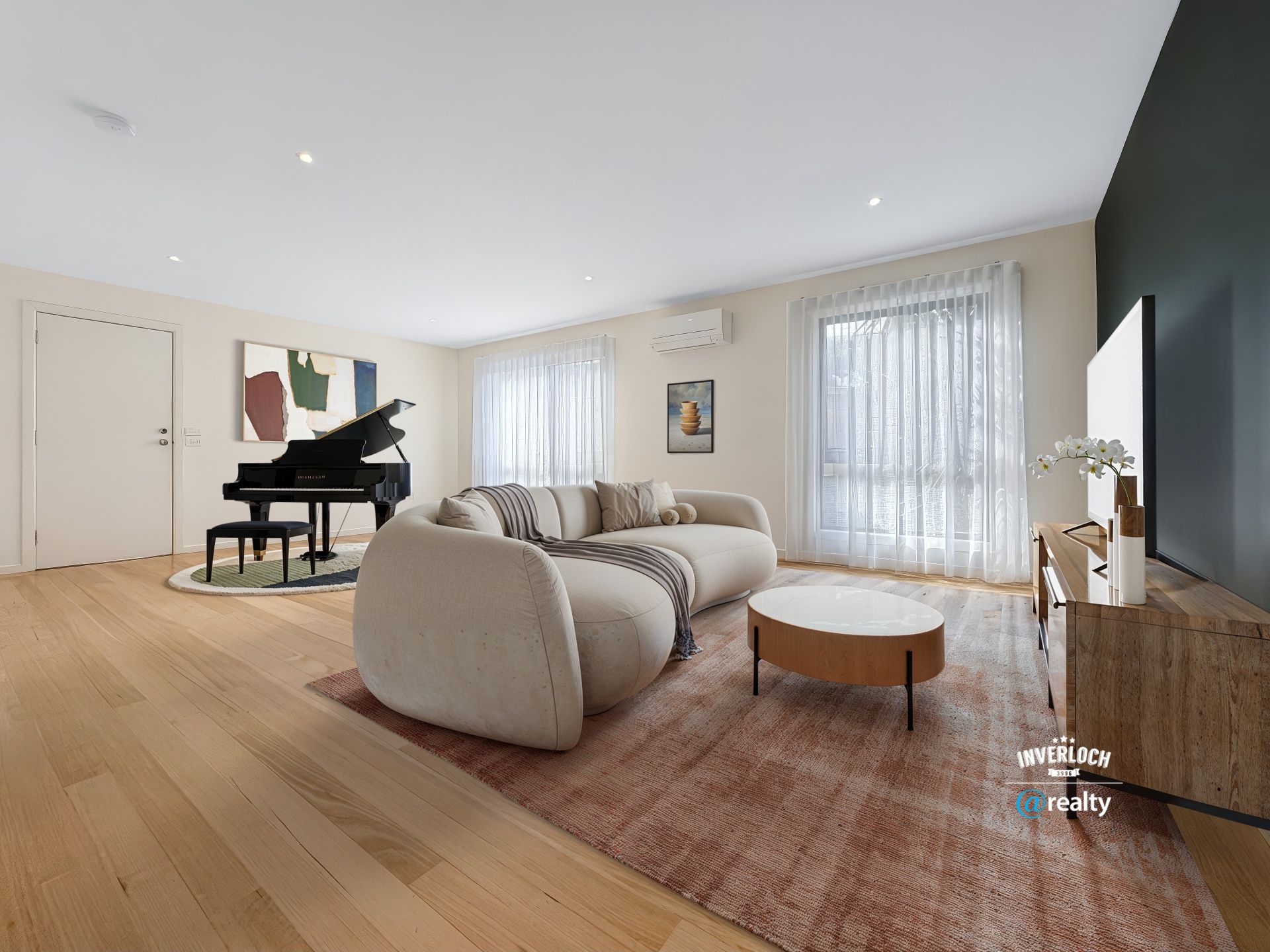 Spacious living room with a grand piano, curved sofa, coffee table, and large windows.