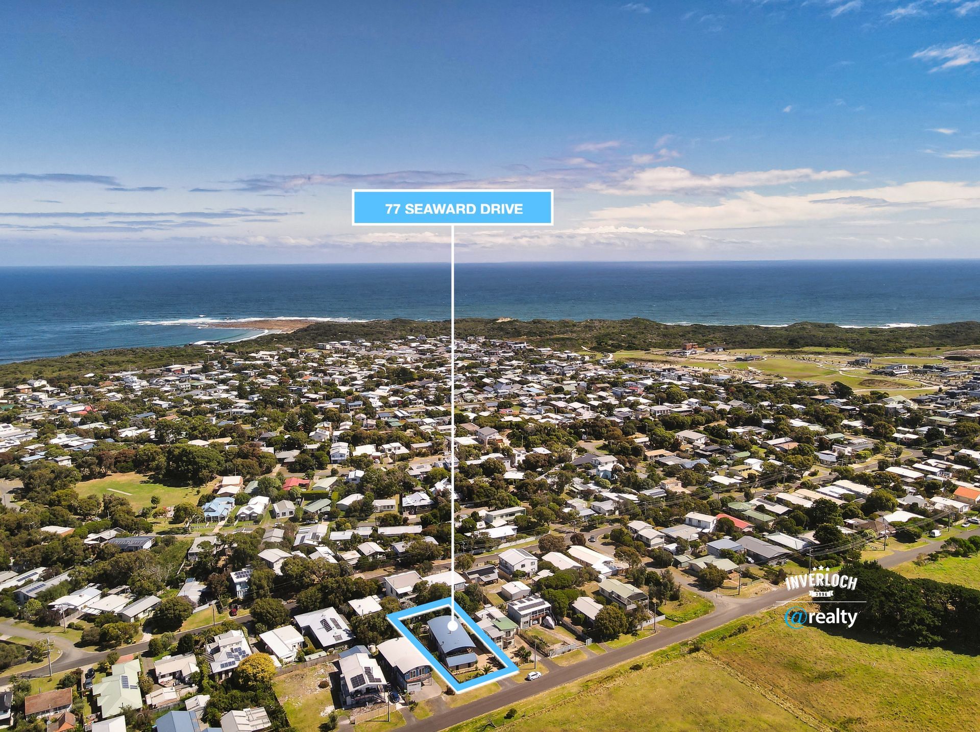 An aerial view of a residential area next to the ocean.