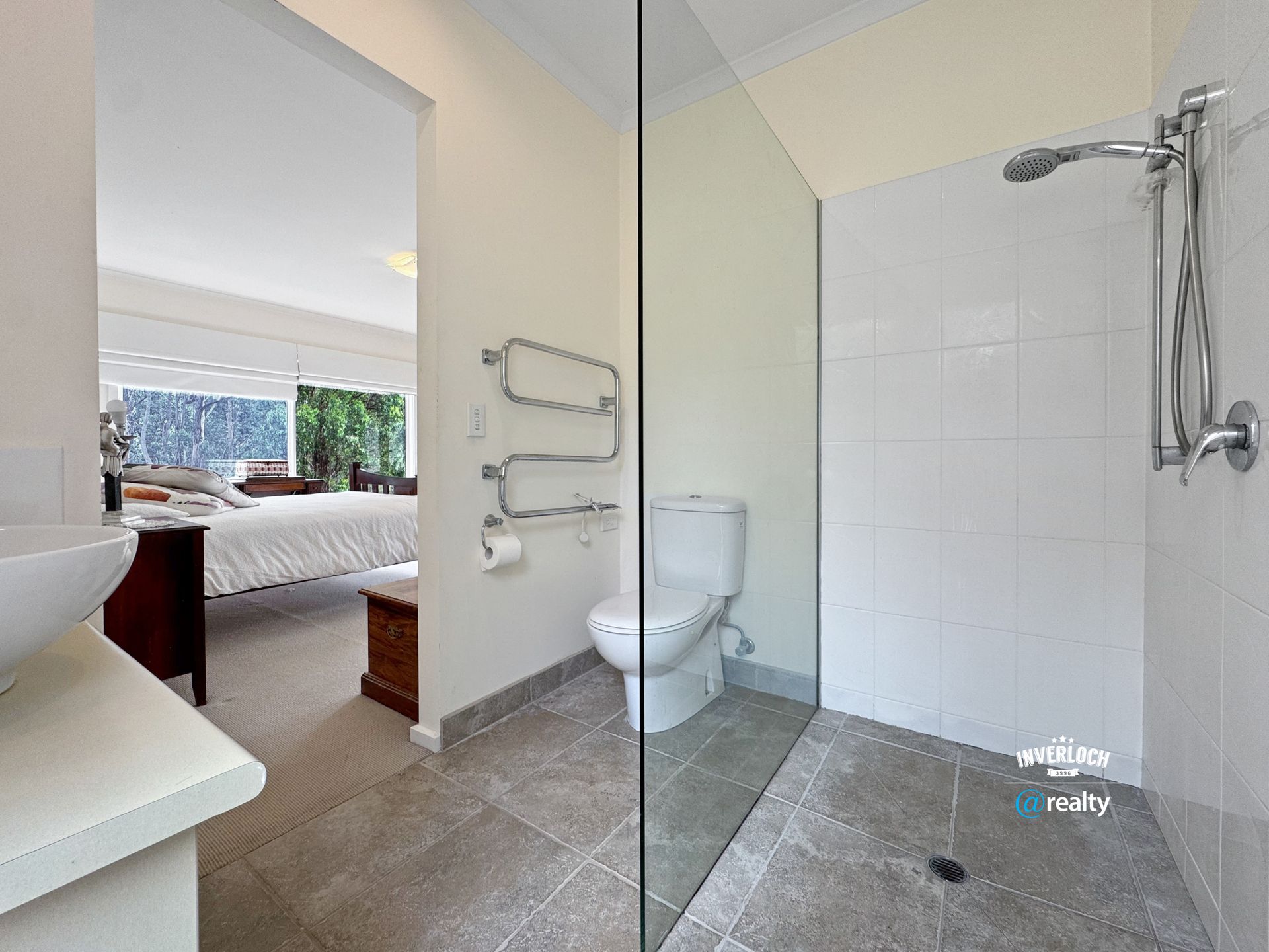 A bathroom with a toilet , sink and walk in shower.