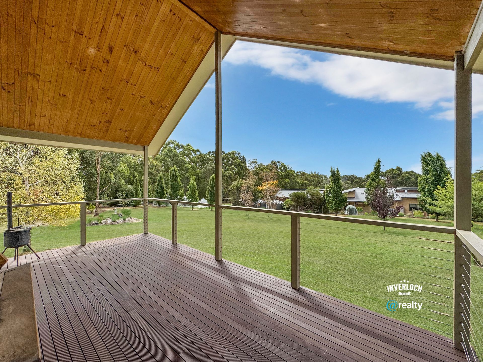 A wooden deck with a view of a grassy field
