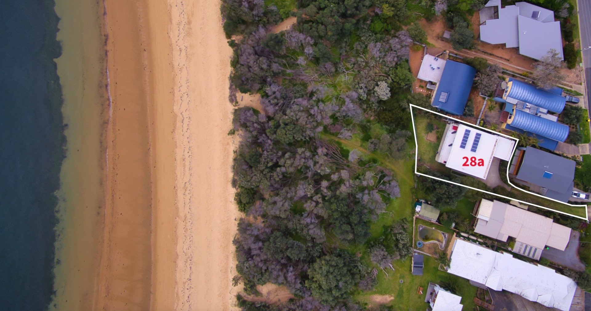An aerial view of a beach with a lot of houses and trees.