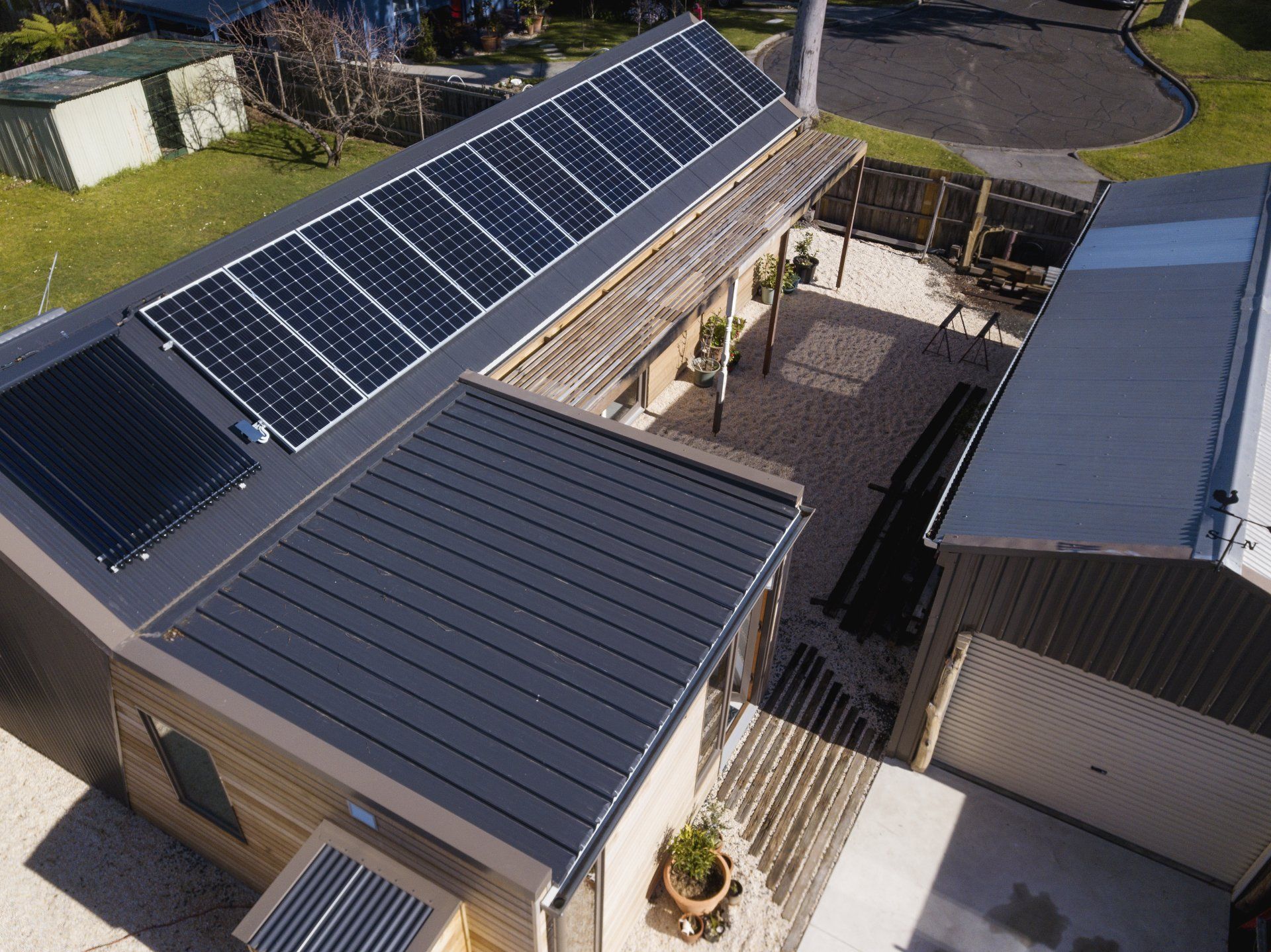 An aerial view of a house with solar panels on the roof.