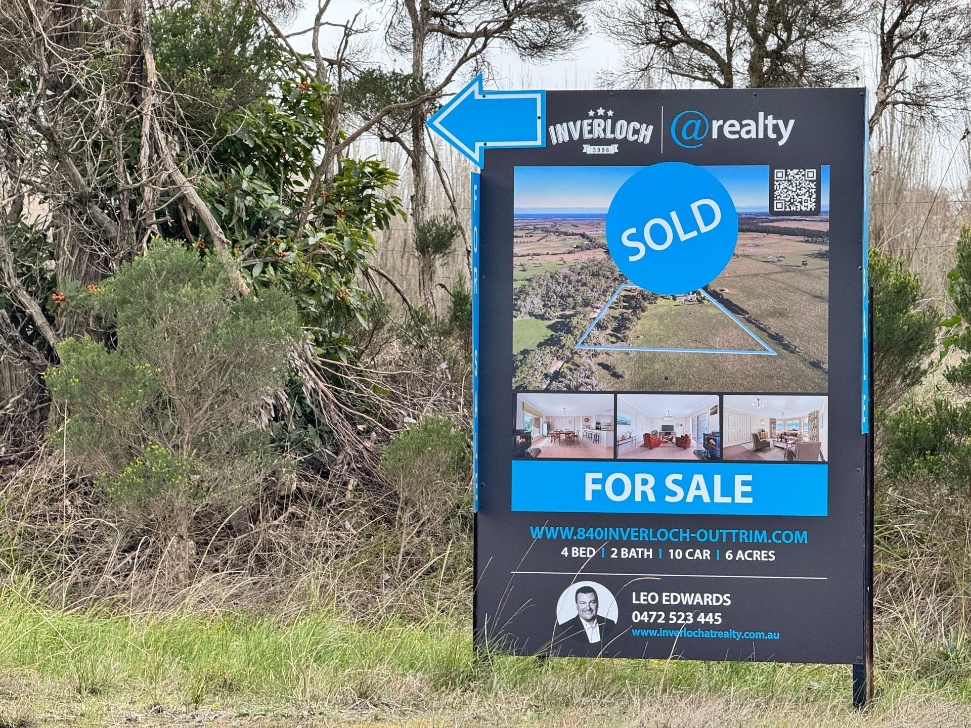 A for sale sign is sitting in the middle of a field.
