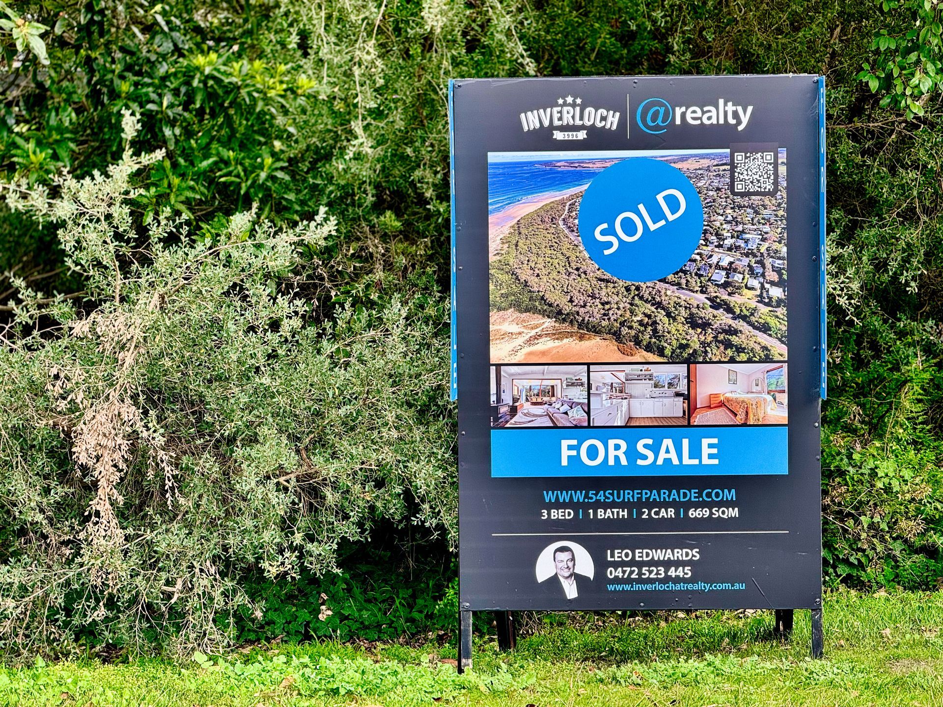 Inverloch real estate agent Leo presenting sold property sign at 54 Surf Parade