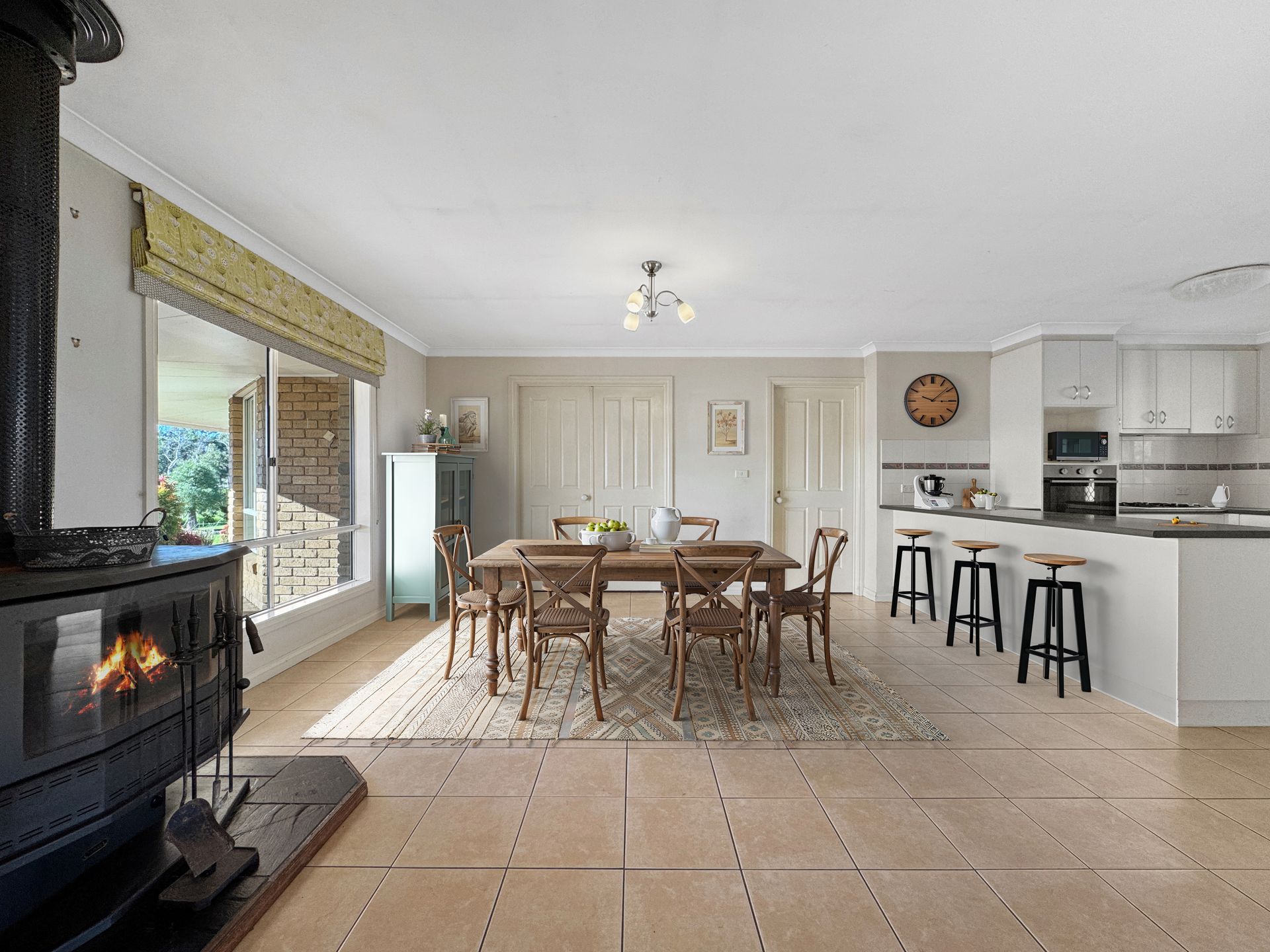 A dining room with a table and chairs and a fireplace.